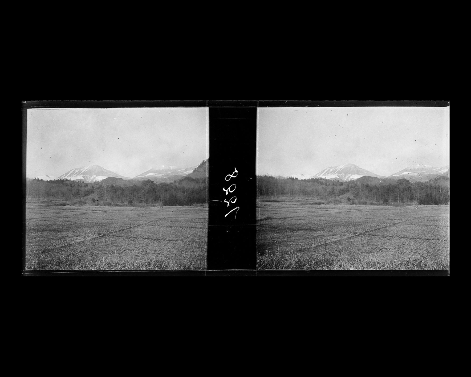 Image représentant Paysage de champs recouvert de givre avec les montagnes enneigées à l'arrière-plan