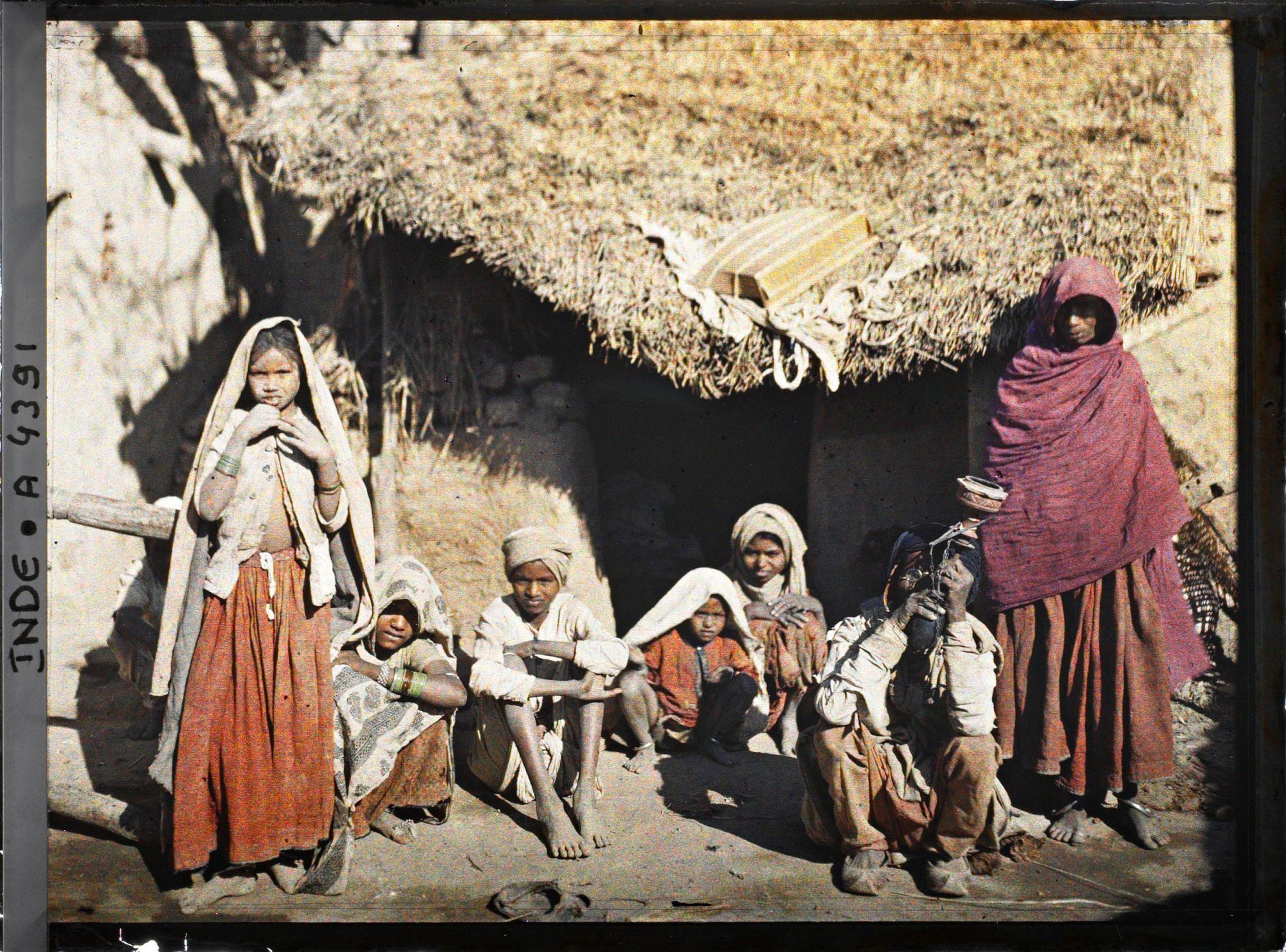 Image représentant Un groupe de villageois (ou famille ?) à l'entrée d'une maison ; l'homme assis fume le "Hukka"