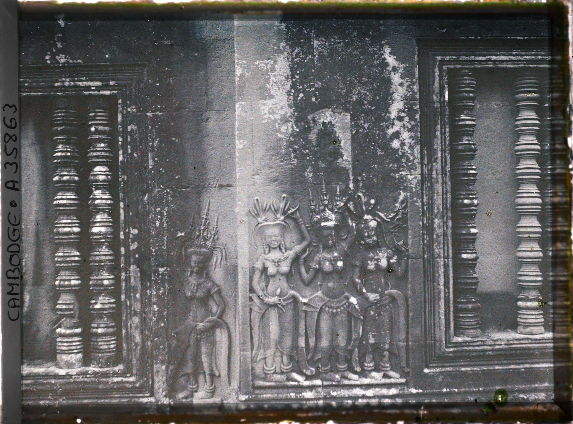 Image représentant Un relief d'apsaras sculpté entre deux fenêtres à balustres d'une galerie