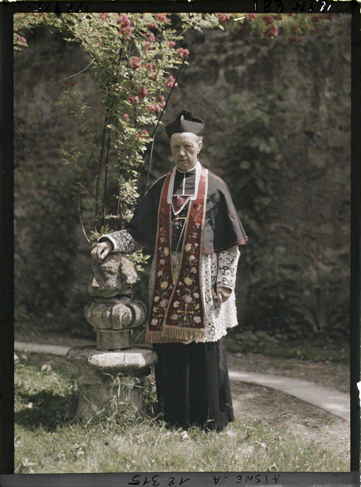 Image représentant Monseigneur Landais, archiprêtre de la cathédrale posant près d'une statue