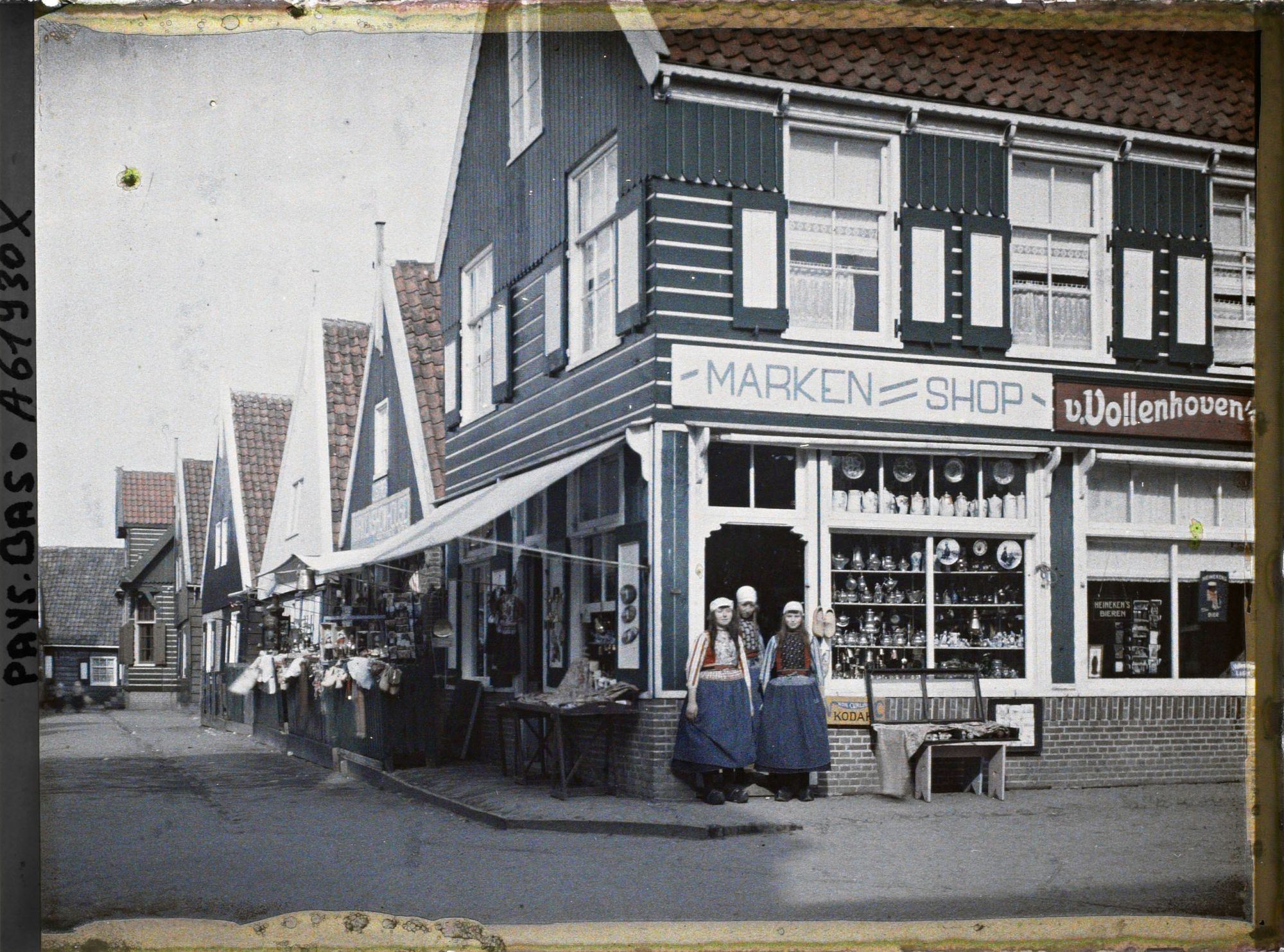 Image représentant Jeunes filles en costume de l'île à l'entrée d'un magasin de souvenirs