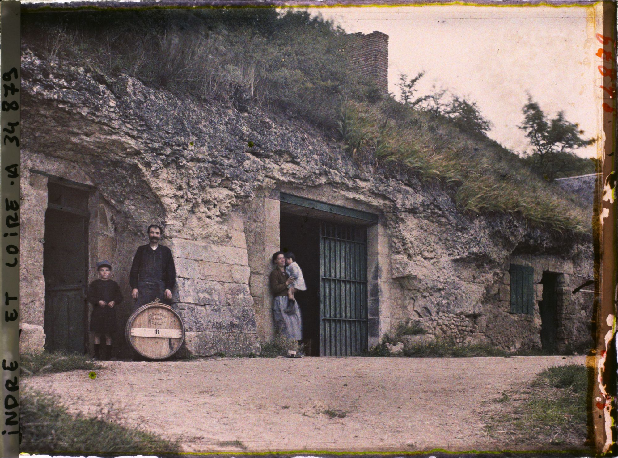 Image représentant Homme, Femme et enfants posant devant une cave troglodyte
