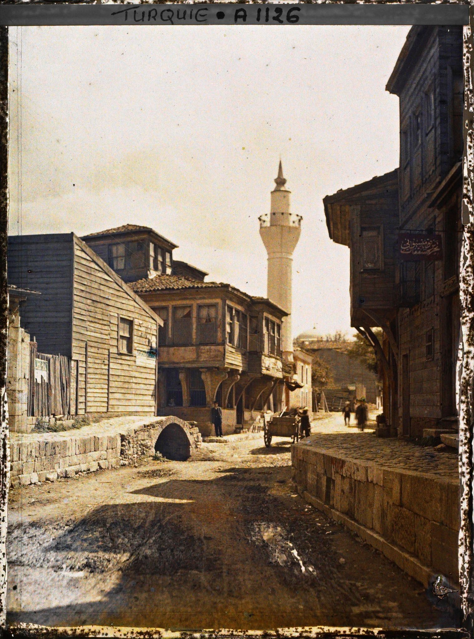 Image représentant Maisons de bois et carriole dans une rue d'Eyüp et au fond, un minaret