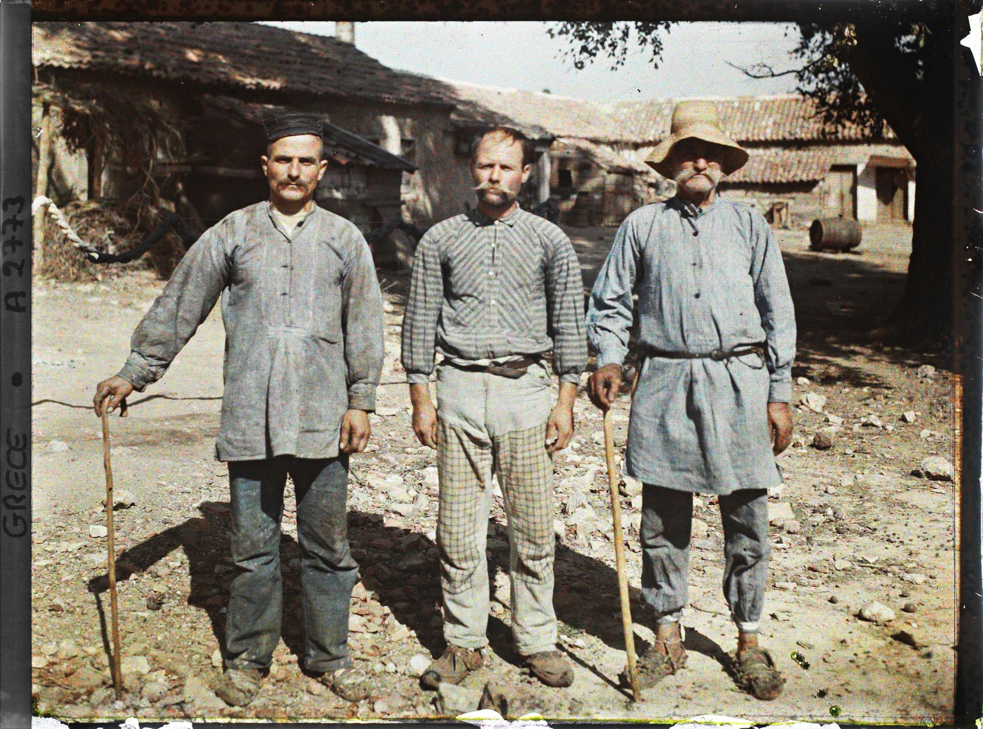 Image représentant Trois paysans (d'origine albanaise) dans une cour de ferme