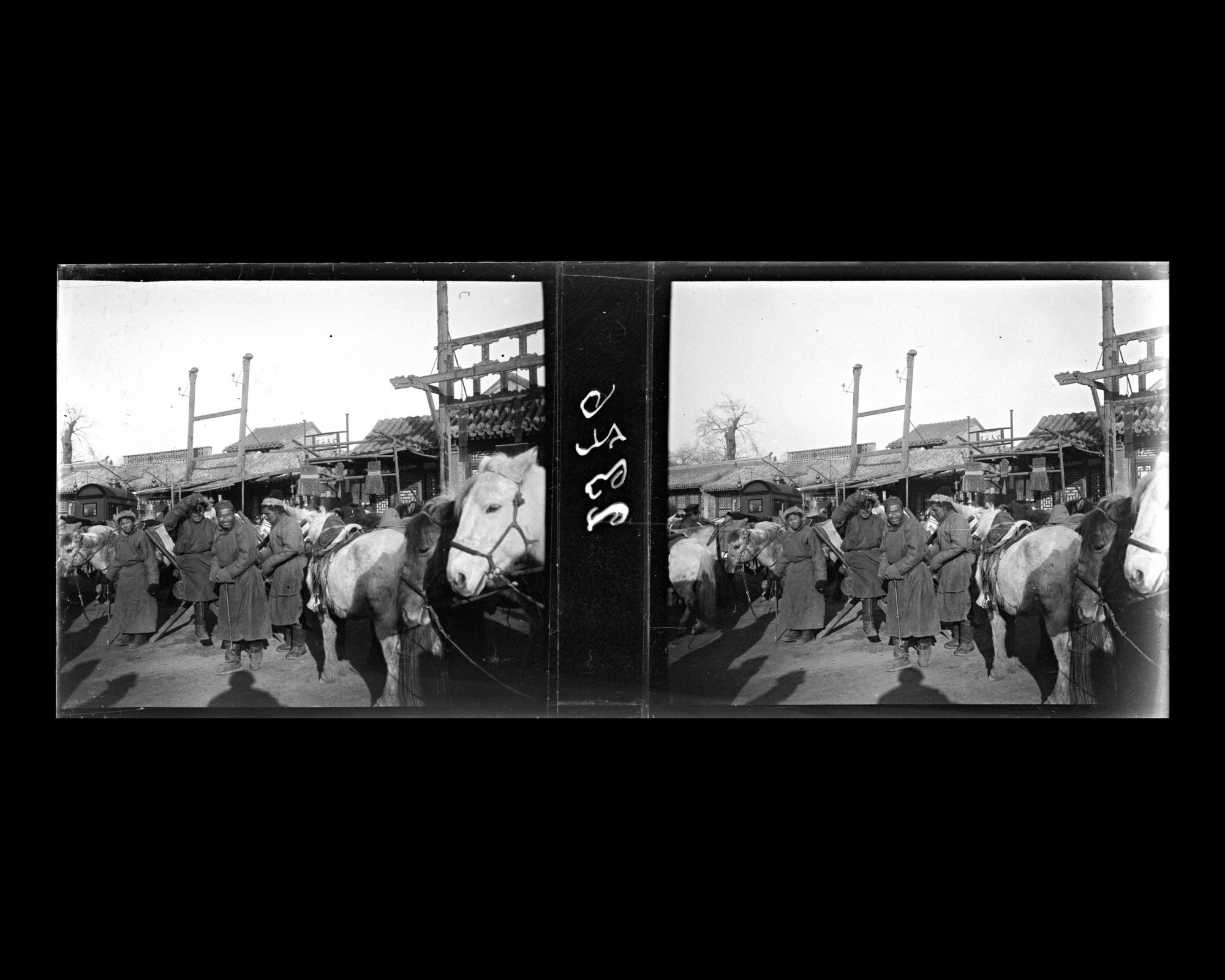 Image représentant Un groupe de Mongols, des chevaux harnachés, à l'arrêt devant des boutiques sur Donganmen dajie ("avenue de la Porte de l'Est")