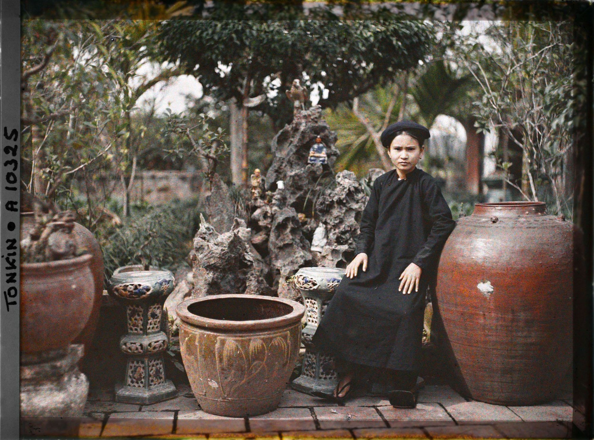 Image représentant Une jeune fille de famille aisée assise dans un jardin, devant un " paradis bouddhique "