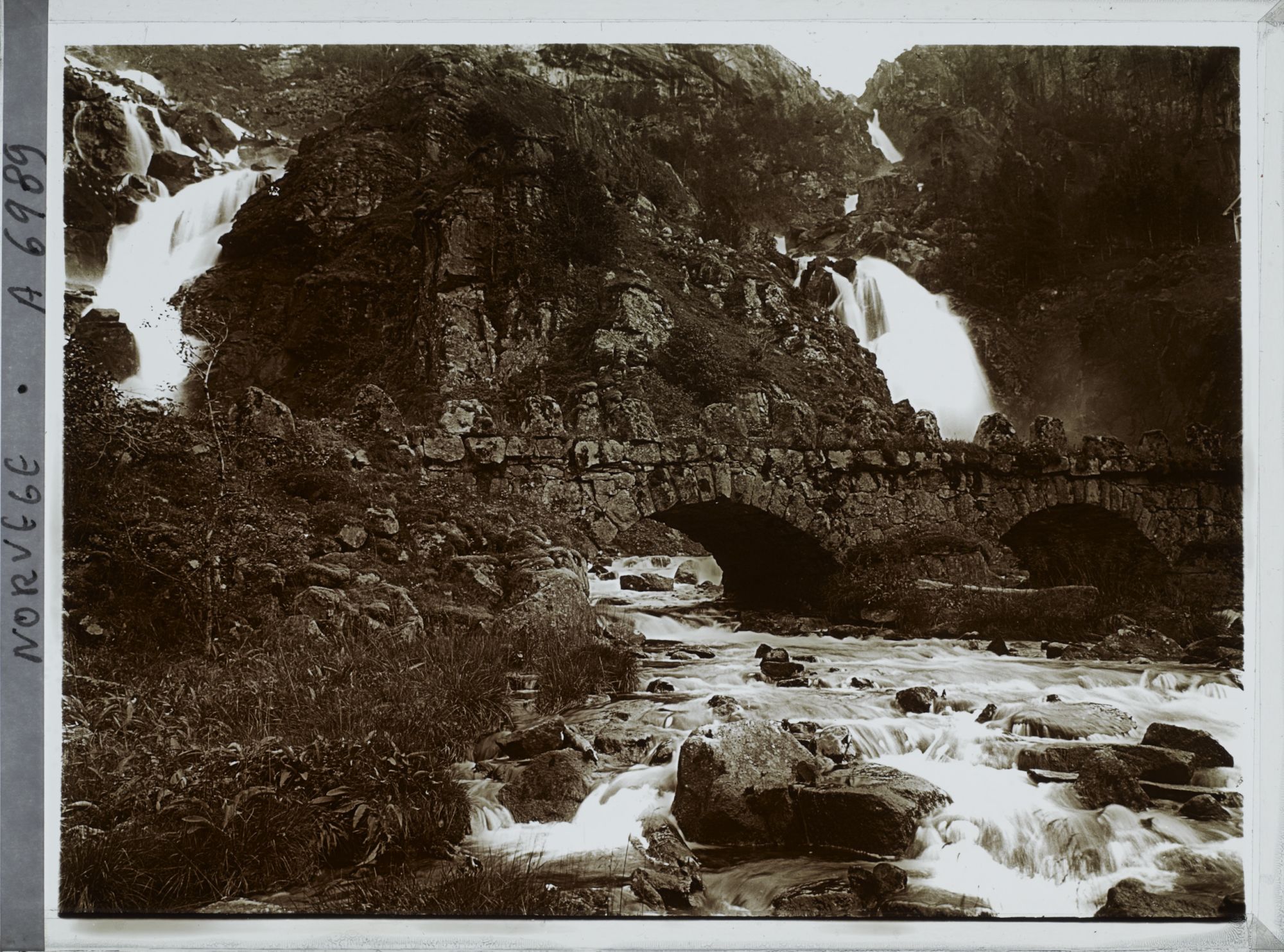 Image représentant Petit pont de pierre en bas d'une cascade
