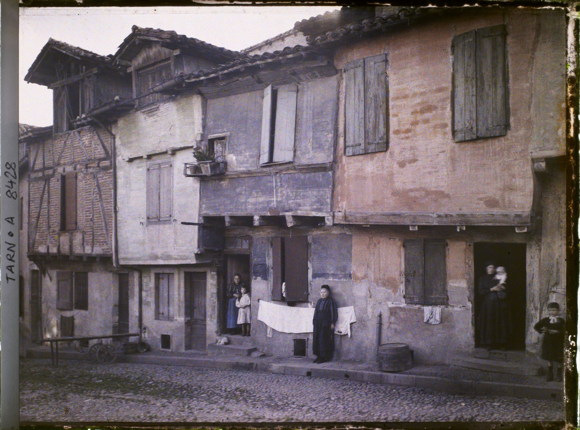 Image représentant Femmes et enfants posant devant les maisons de la place Savène