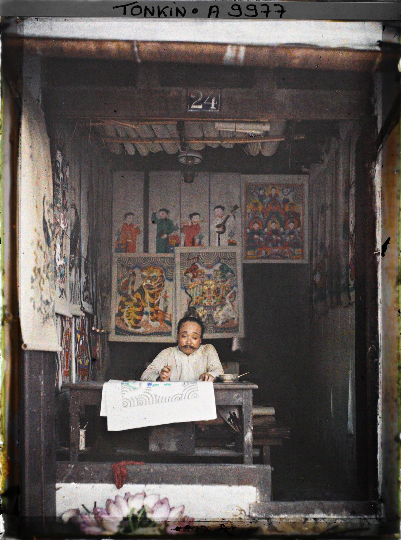 Image représentant Un artisan au travail dans sa boutique d'images peintes, au n° 24 de la rue Jules Ferry