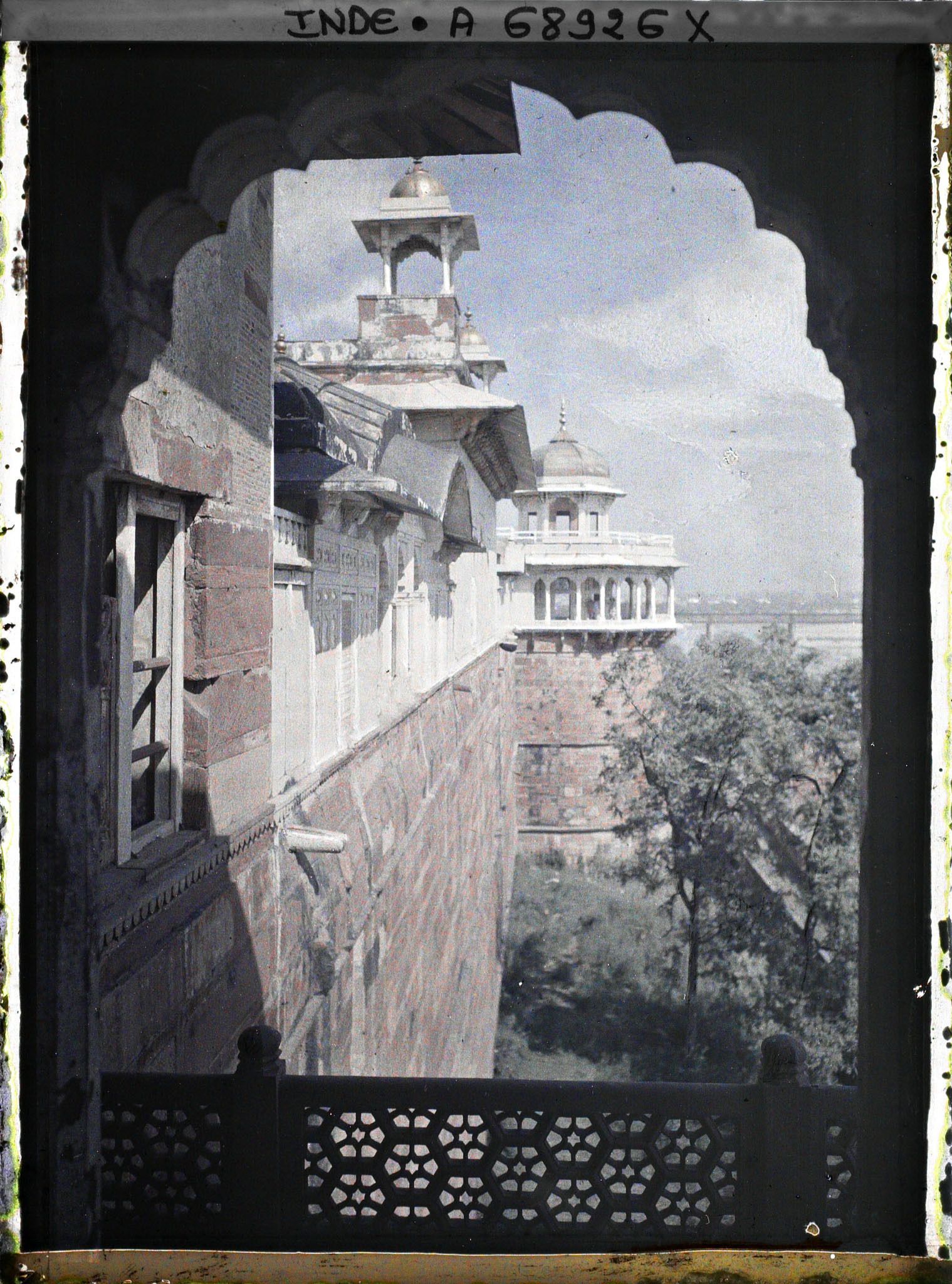 Image représentant Vue sur l'extérieur de l'enceinte du fort Rouge (Lal Qila), la toiture du palais privé (Khas Mahal) surmontée d'un chhatri et au fond, la tour du Jasmin (Musamman Burj)
