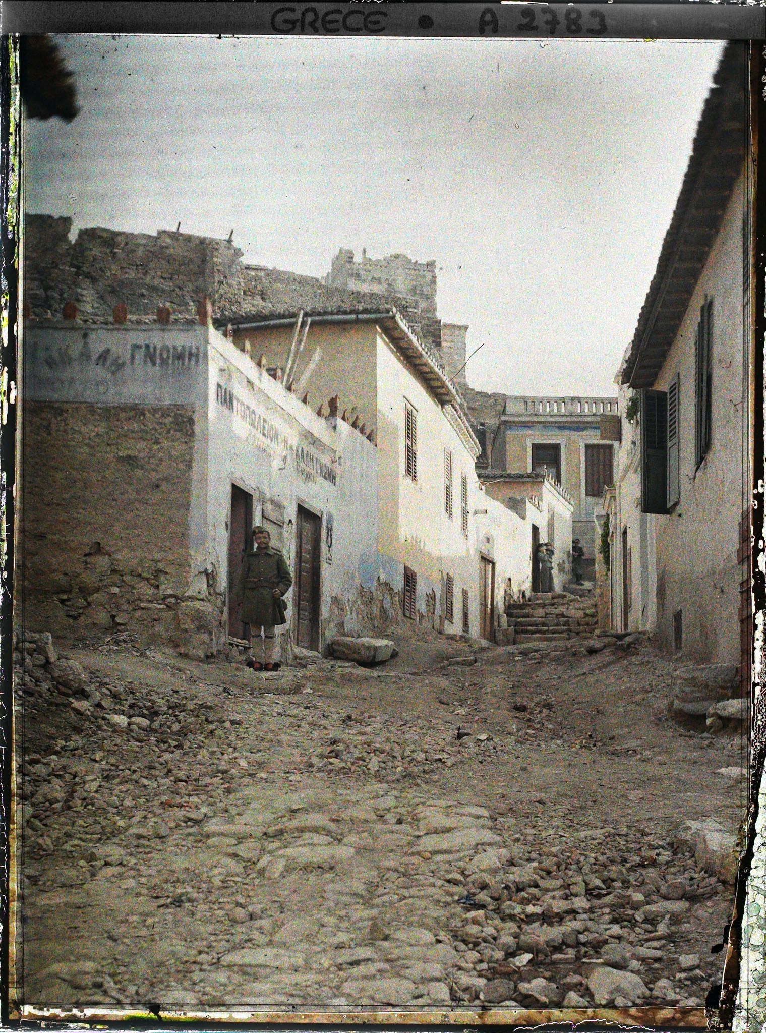 Image représentant Une rue (bordée de maisons) au pied de l'Acropole (fortifications)