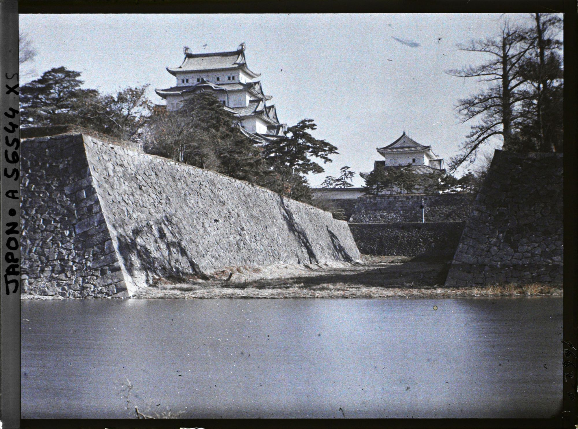 Image représentant Le donjon (tenshu) du château de Nagoya (Nagoya-jôshi) vu depuis le fossé externe (Soto-bori) ouest.