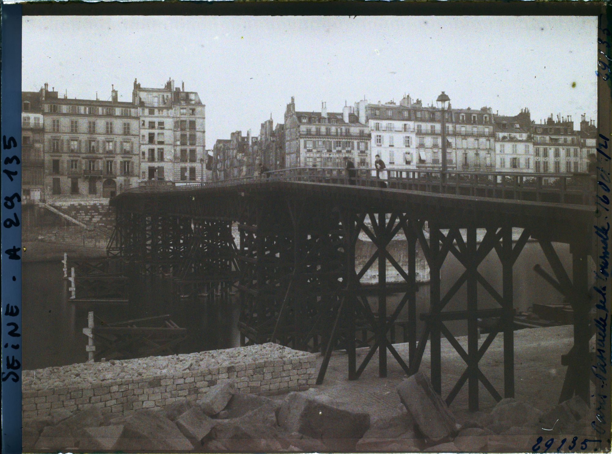 Image représentant La passerelle en bois remplaçant provisoirement le pont de la Tournelle en reconstruction, vue depuis le quai de la Tournelle vers les quais d'Orléans et de Béthune