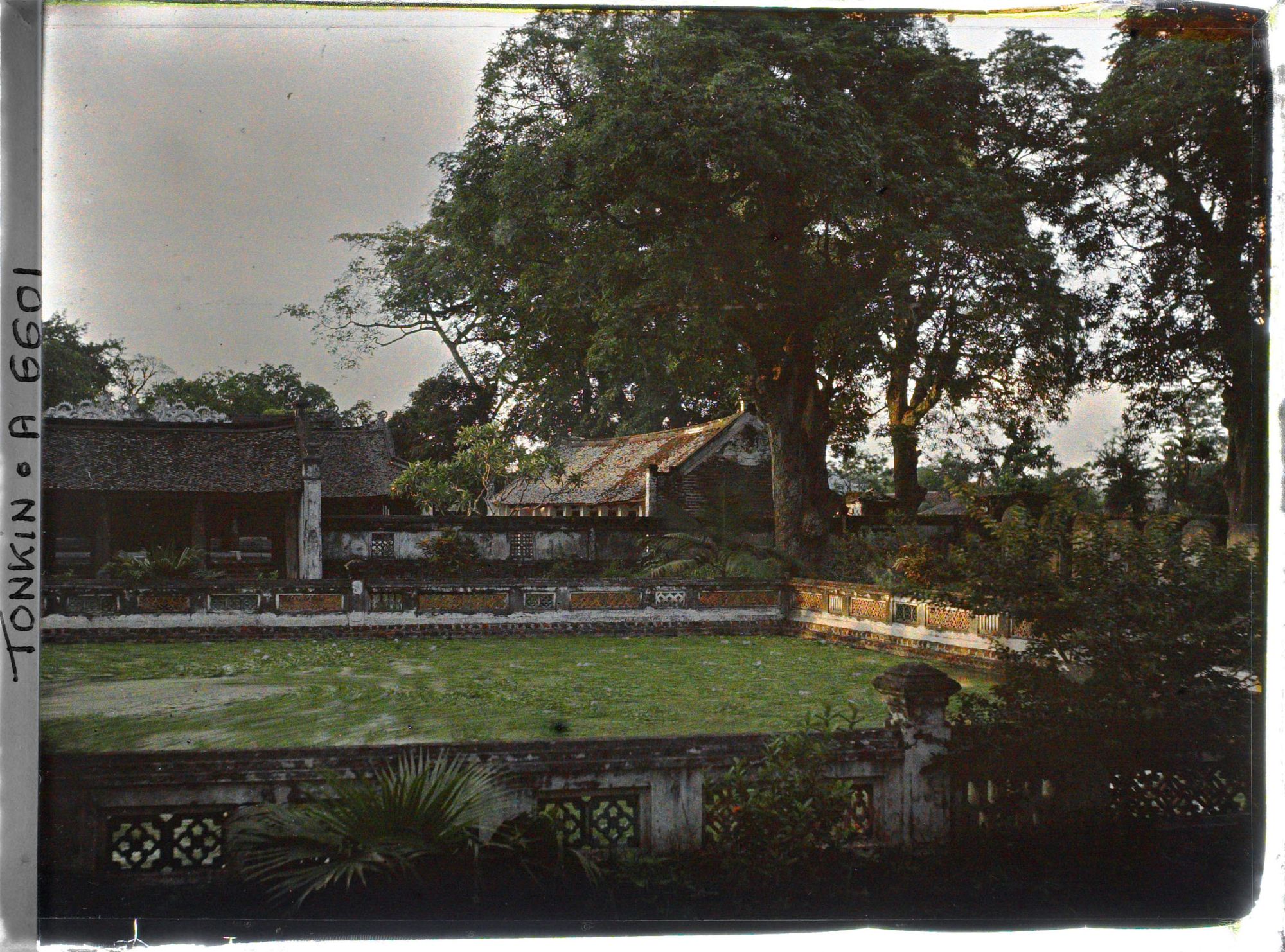Image représentant Le soleil couchant sur l'angle nord-est de la troisième cour du Van-mieu, avec le bassin Thien-quang-tinh (" puits où se reflète l'éclat pur du ciel ") et une vue partielle sur la quatrième cour