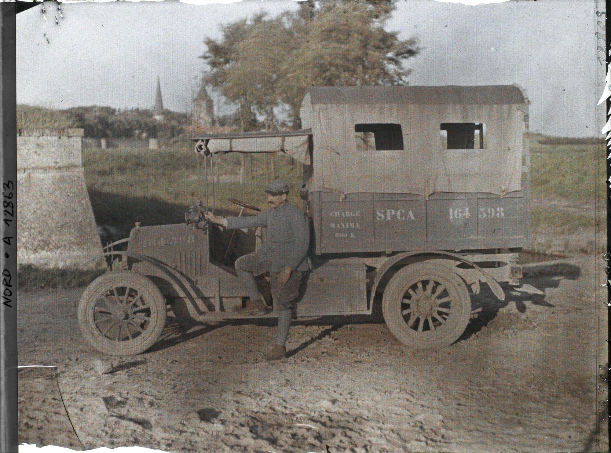 Image représentant Un soldat devant une camionnette de la Section Photographique et Cinématographique de l'Armée (S.P.C.A.)