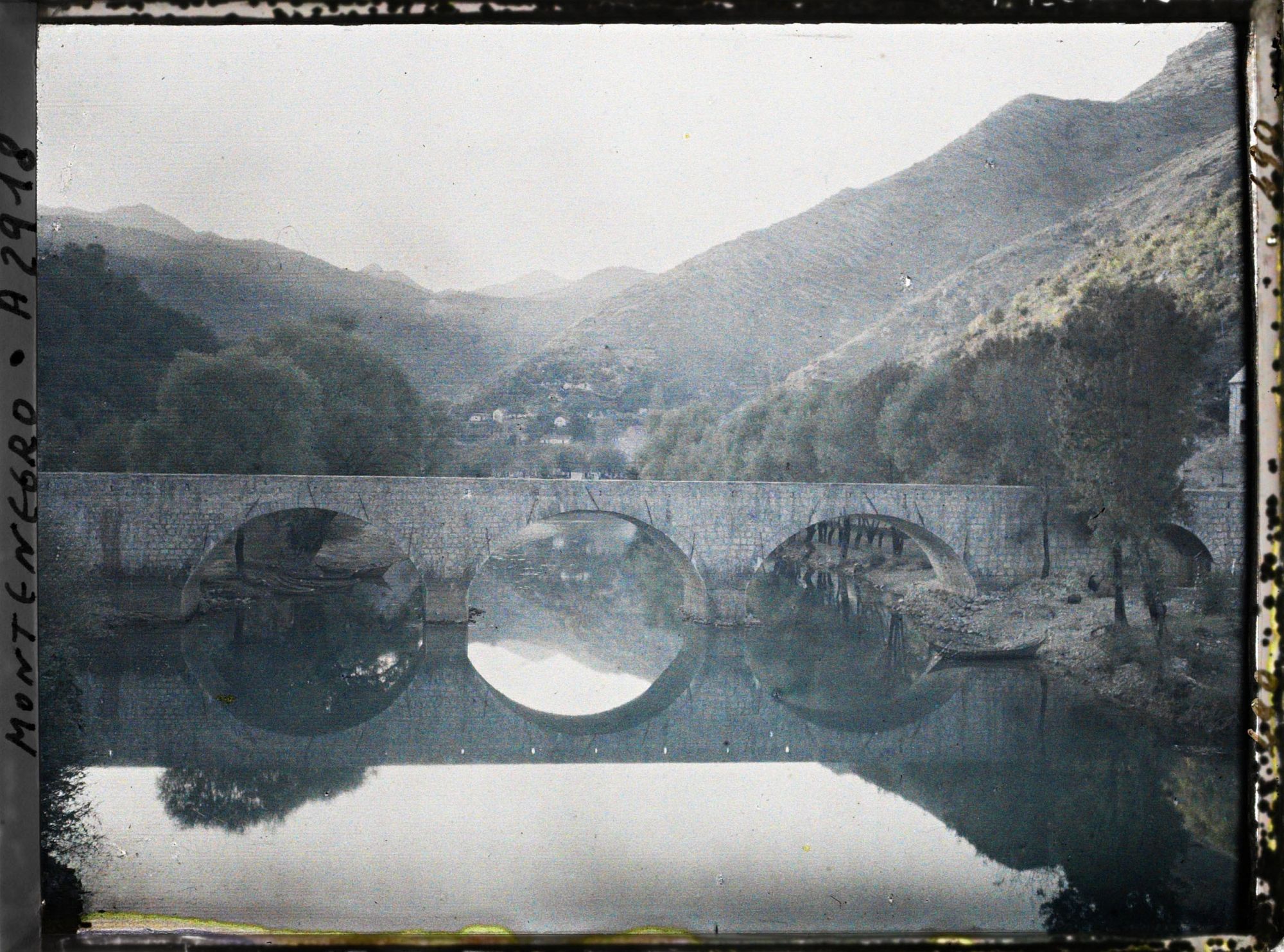 Image représentant Le pont, la rivière (avec reflets) et le village dans le lointain