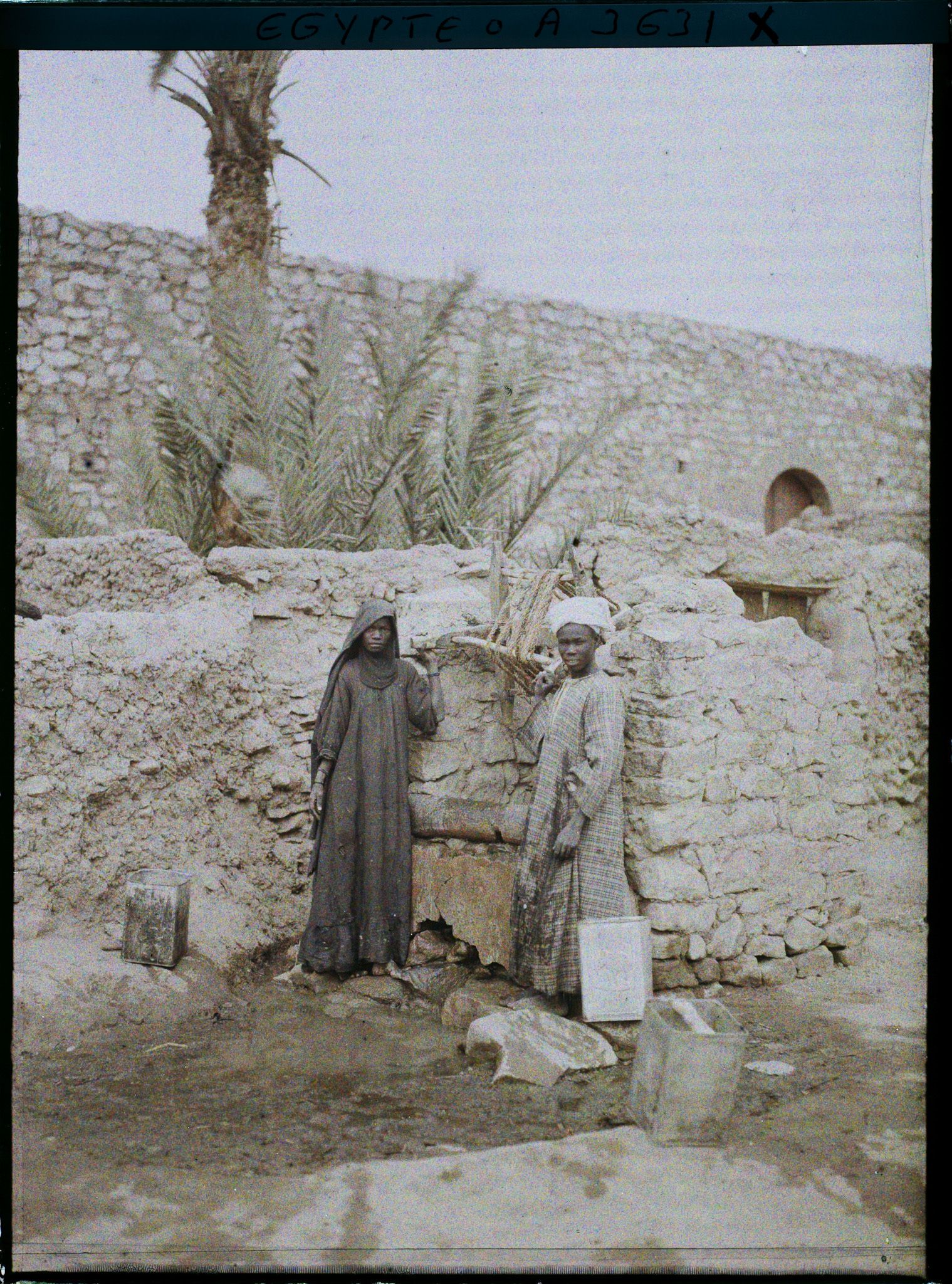 Image représentant Deux nubiennes posent pour l'opérateur près d'un puits