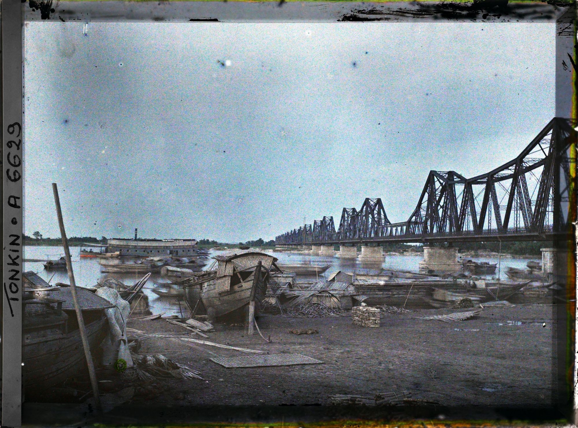 Image représentant Des sampans sur les quais du Fleuve Rouge, près du pont Doumer, au coucher du soleil