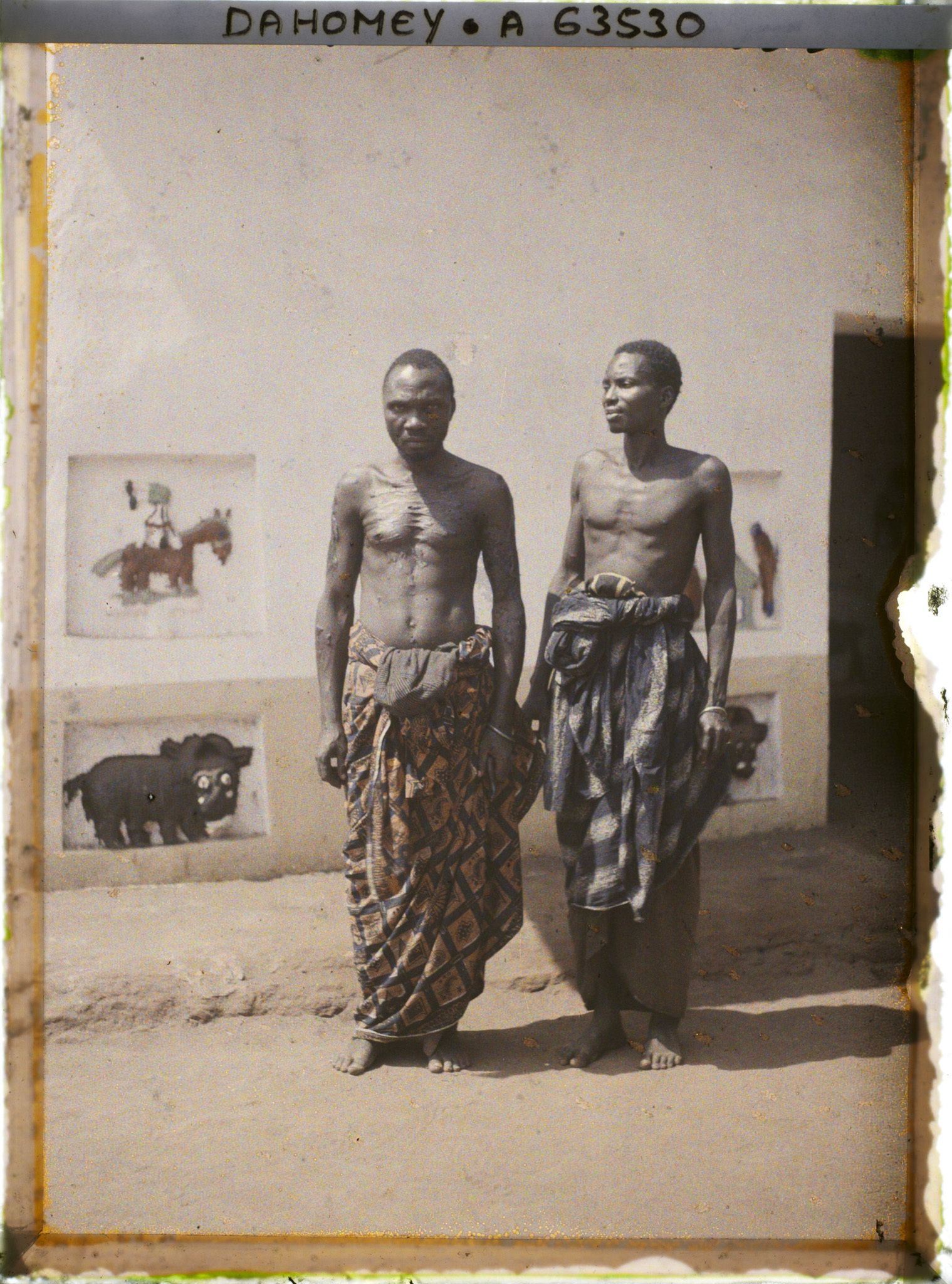 Image représentant Les deux artistes restaurateurs des reliefs des palais, devant l'ajalala (bâtiment de réception) de  null Guézo