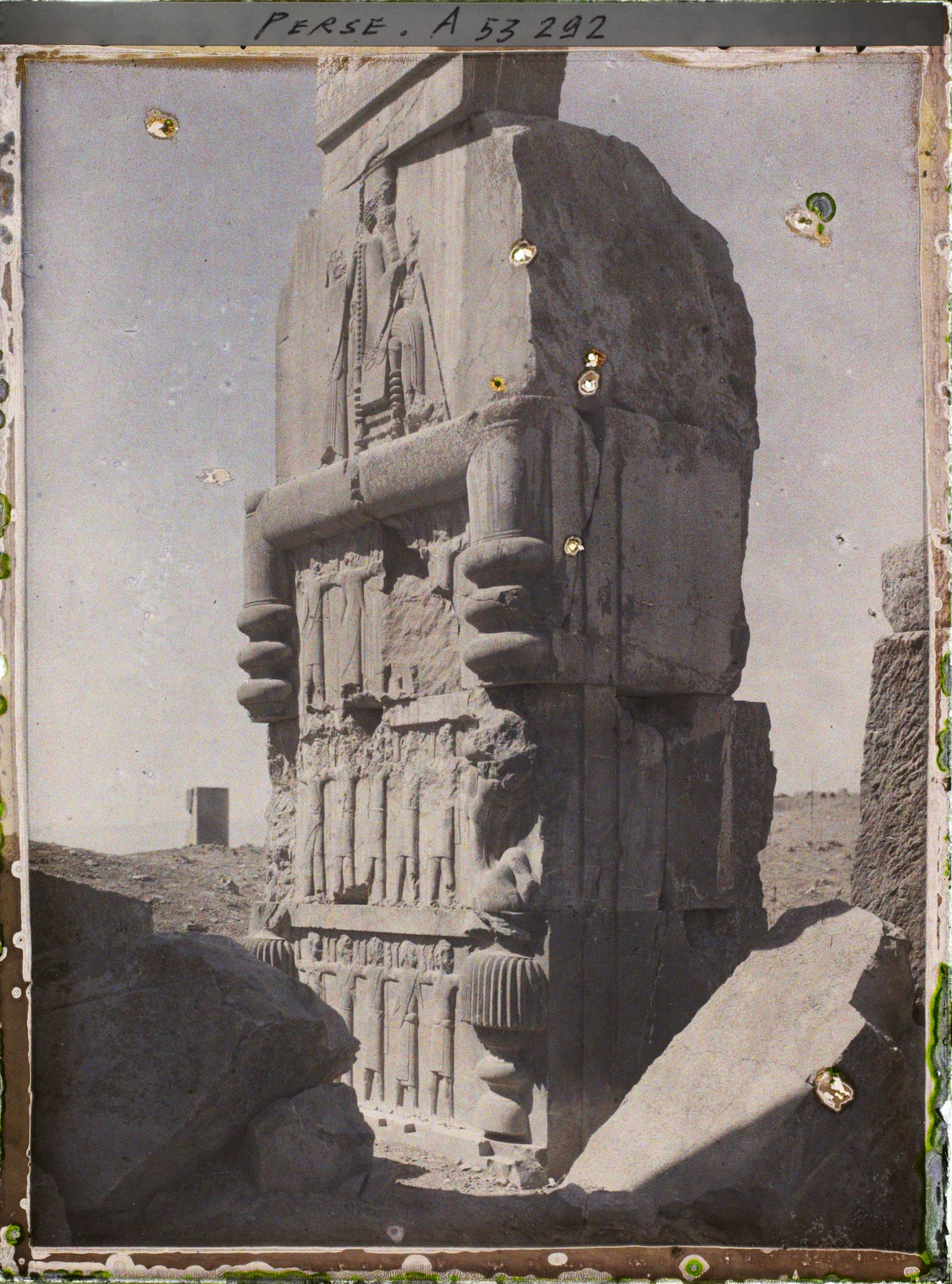 Image représentant Dans l'embrasure de la porte orientale du Tripylon, bas-relief représentant le roi Darius sur son trône sous le symbole ailé d'Ahura Mazda, soutenu par les 28 nations vassales