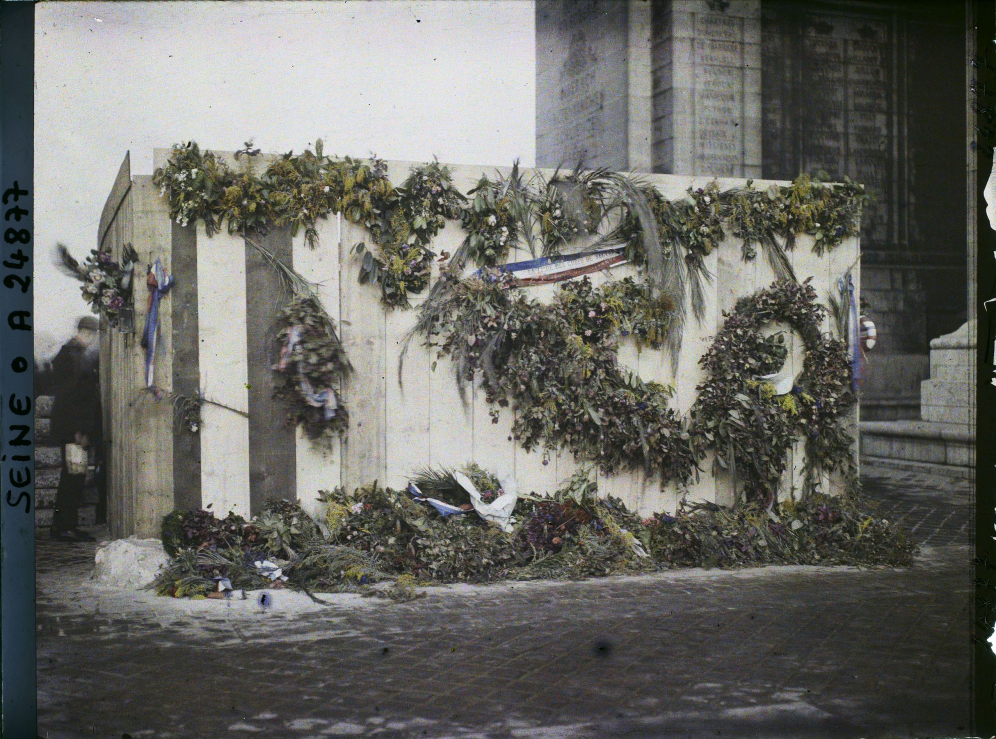 Image représentant Palissade recouverte de fleurs à l'endroit où sera inhumé le 28 janvier 1921 le soldat inconnu, sous l'Arc de Triomphe