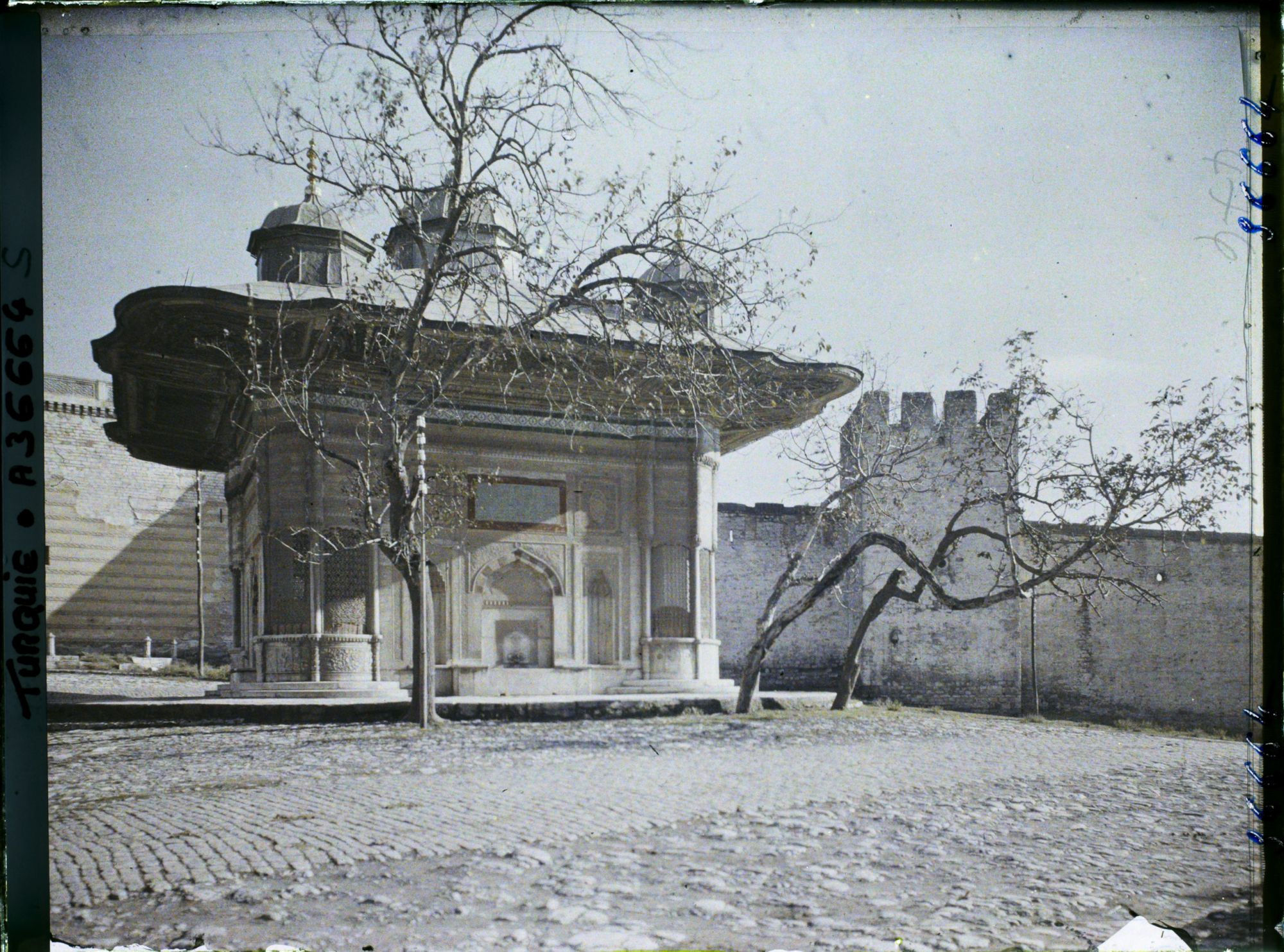 Image représentant Sultan Ahmet Ceshesi ("fontaine du Sultan Ahmet III") devant le mur du palais de Topkapi