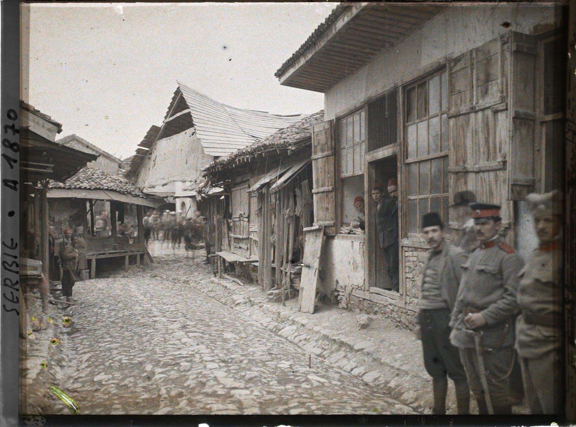 Image représentant Habitants et soldats serbes dans une rue bordée d'échoppes