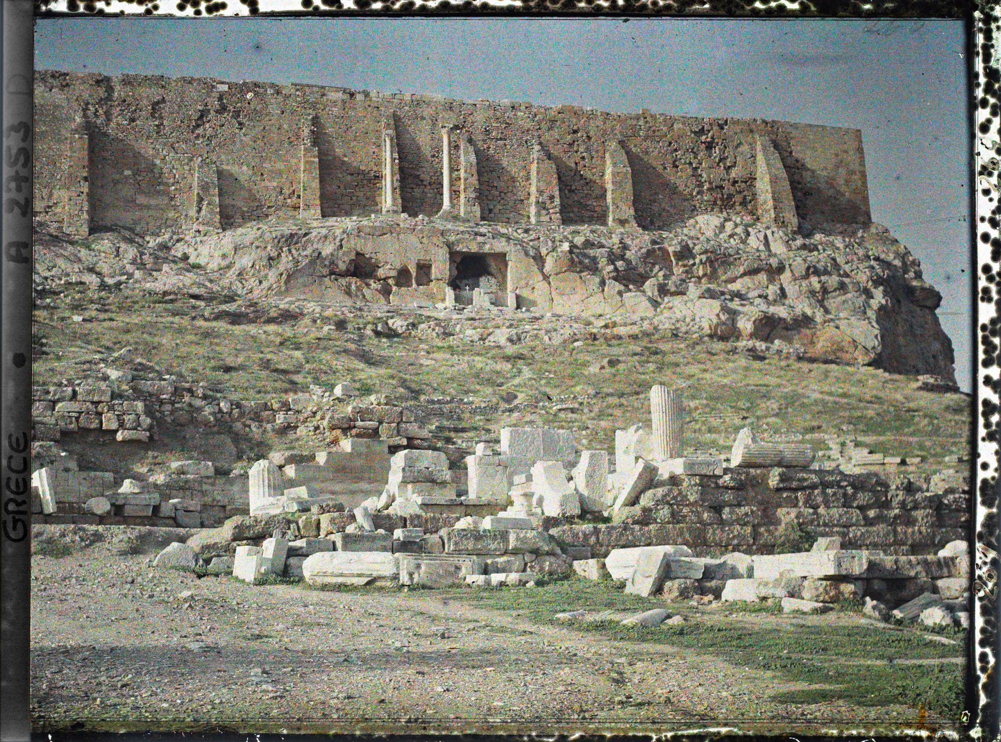 Image représentant Vestiges de l'arrière scène du Théâtre de Dyonisos. Au-dessus, sous le mur sud de l'Acropole, la chapelle de la Vierge de la grotte