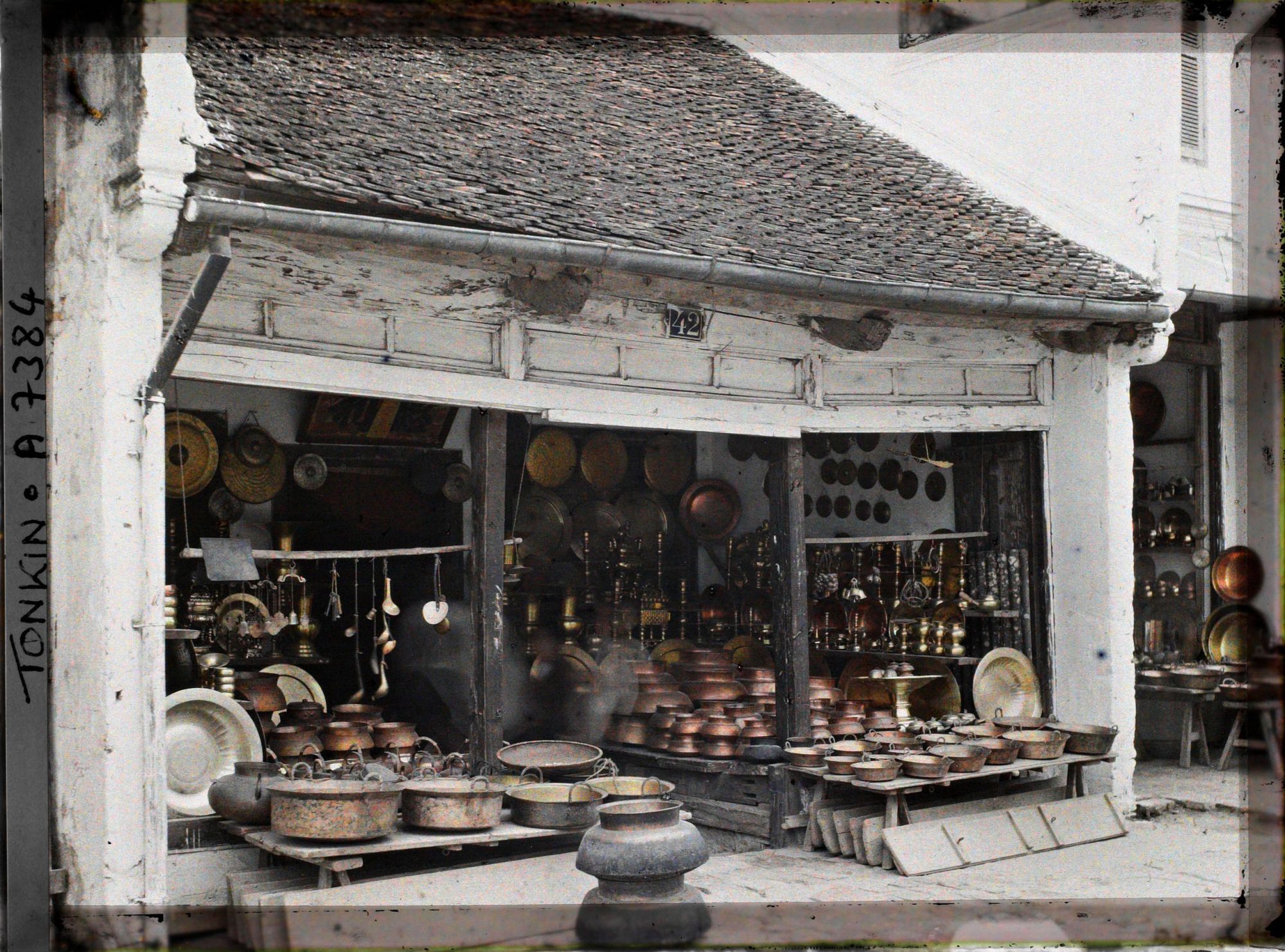 Image représentant Un étalage d'objets en cuivre (trépieds, vases...), à l'intérieur d'une boutique, dans la " rue du Cuivre "