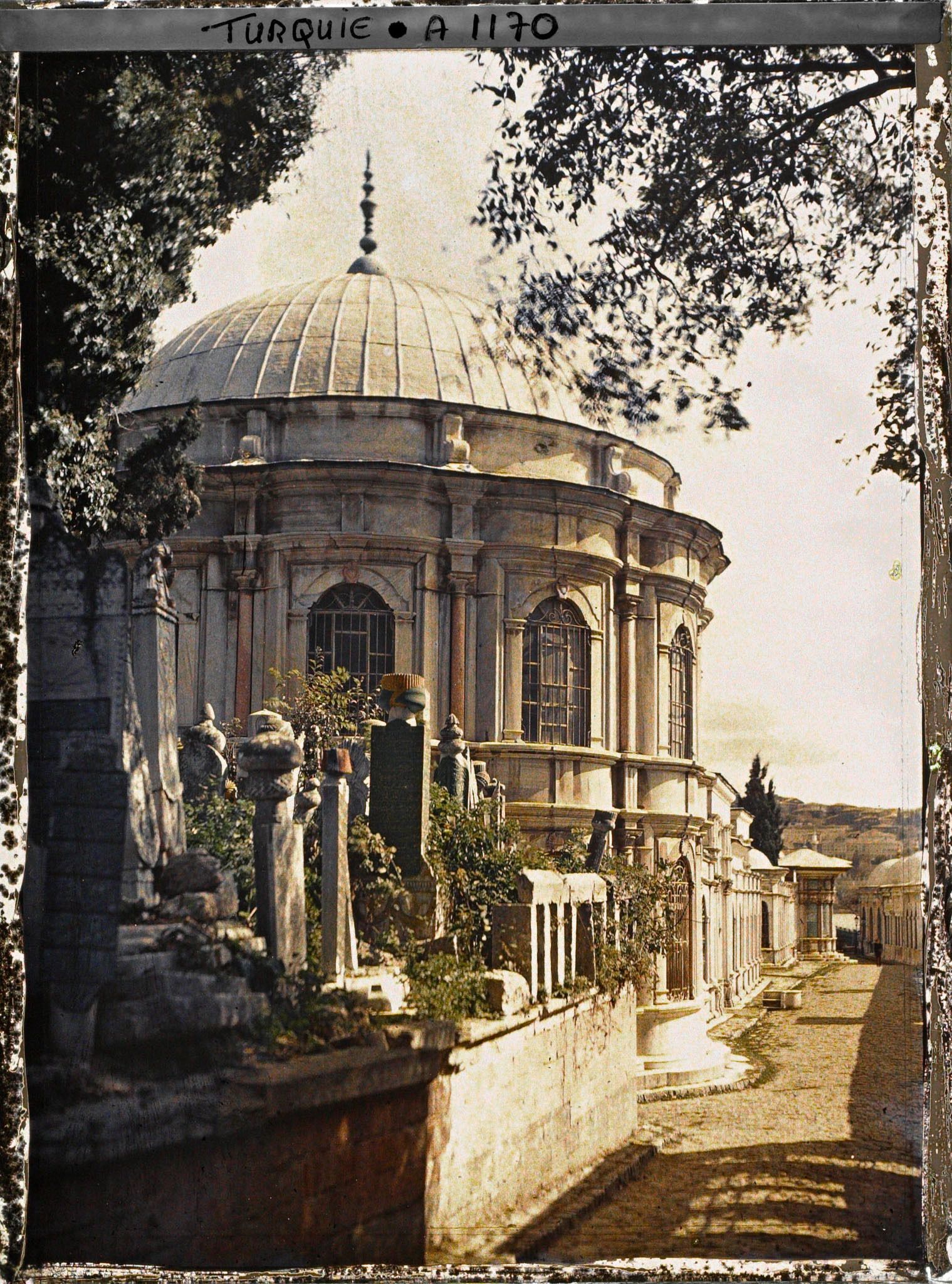Image représentant Un mausolée et des tombes le long d'une rue pavée du cimetière de l'Eyüp Sultan Camii