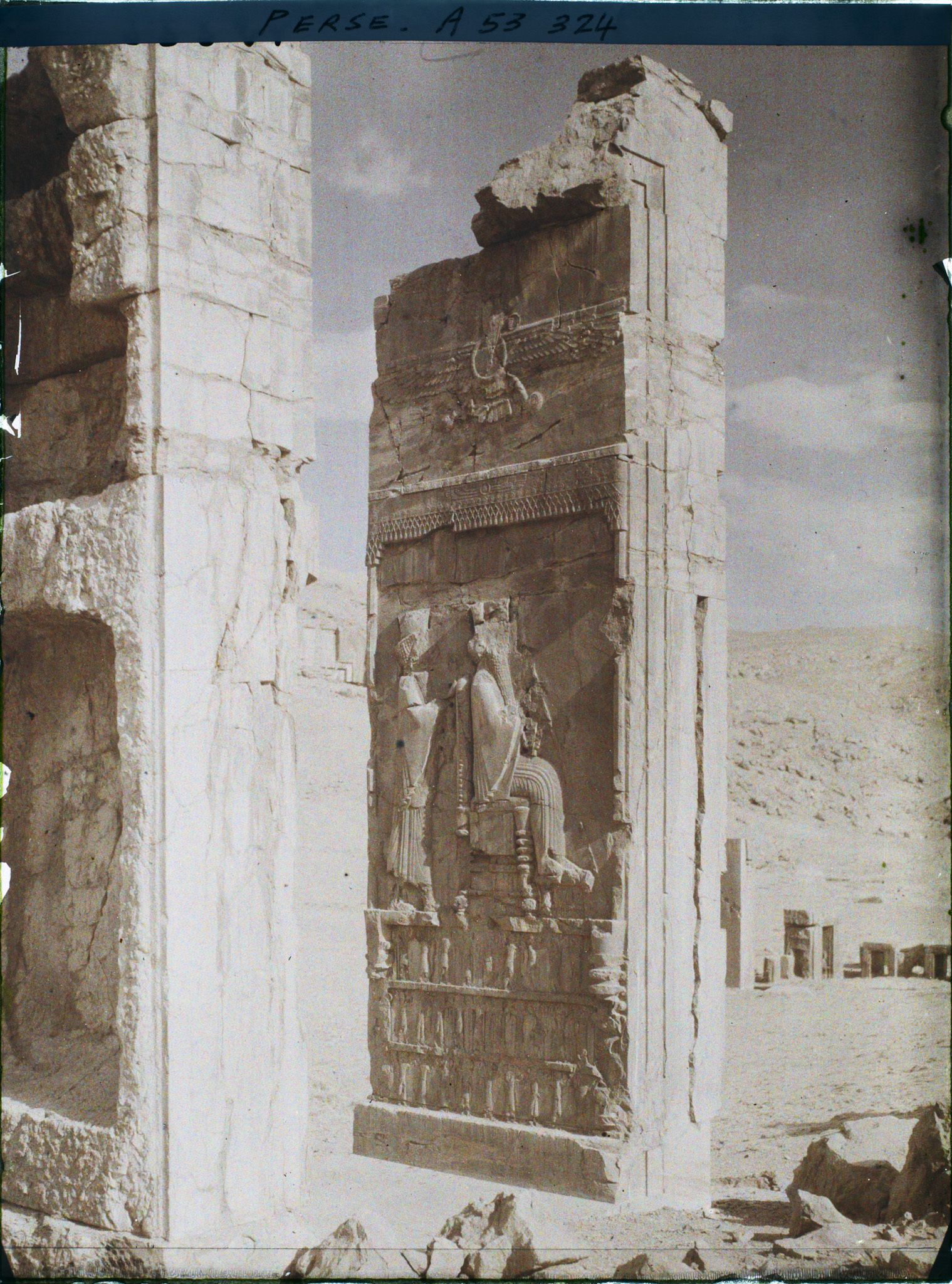 Image représentant Le Tripylon, bas-relief représentant Darius sur son trône devant Xerxès en prince couronné, sous le symbole ailé d'Ahura Mazda et soutenus par les 28 nations vassales