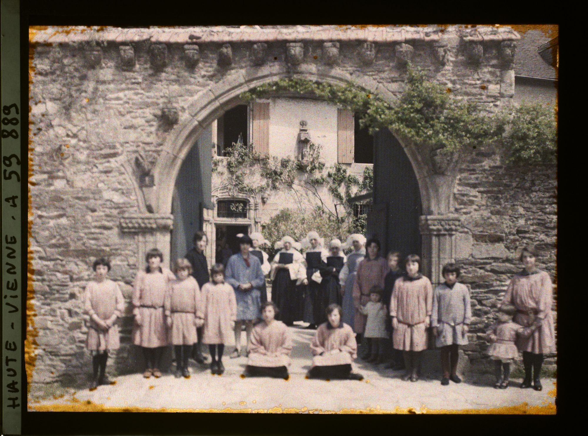 Image représentant Un groupe de jeunes filles et de soeurs posant devant l'orphelinat du couvent des Clarisses