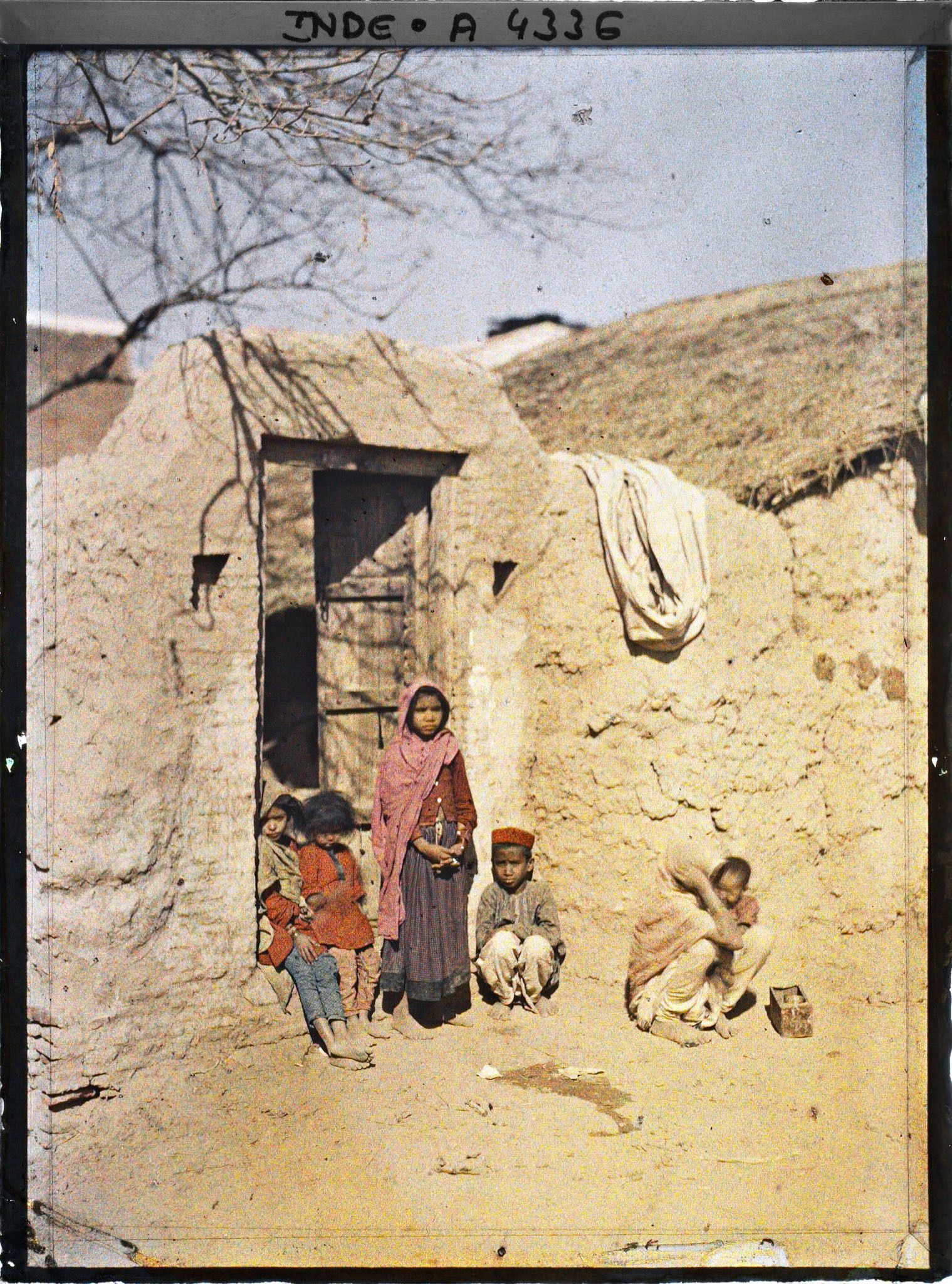Image représentant Femme et enfants à l'entrée d'une maison