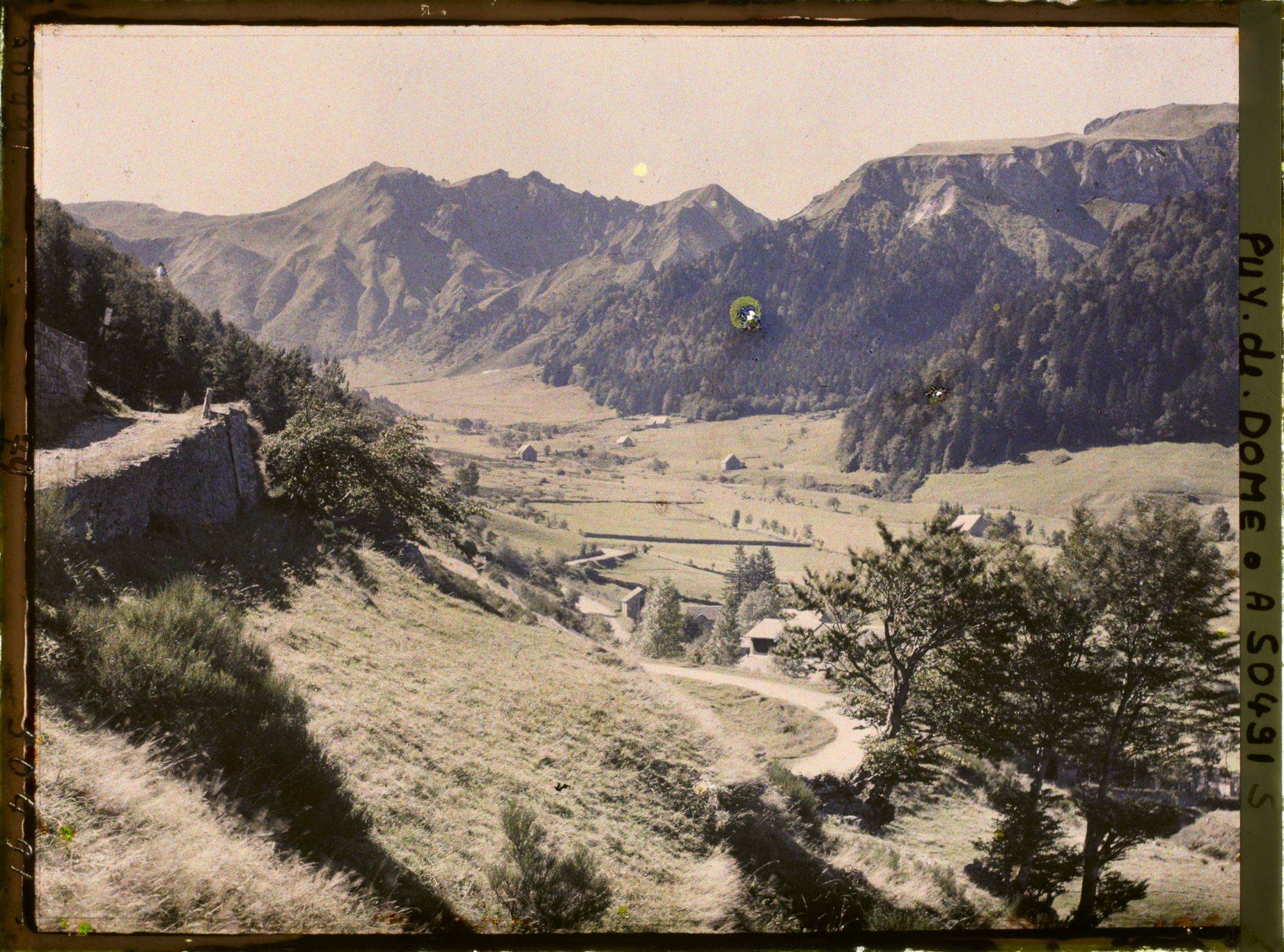 Image représentant France, Mont-Dore, Le fond de la vallée et les Burons et la route de Besse ; au fond, le Sancy