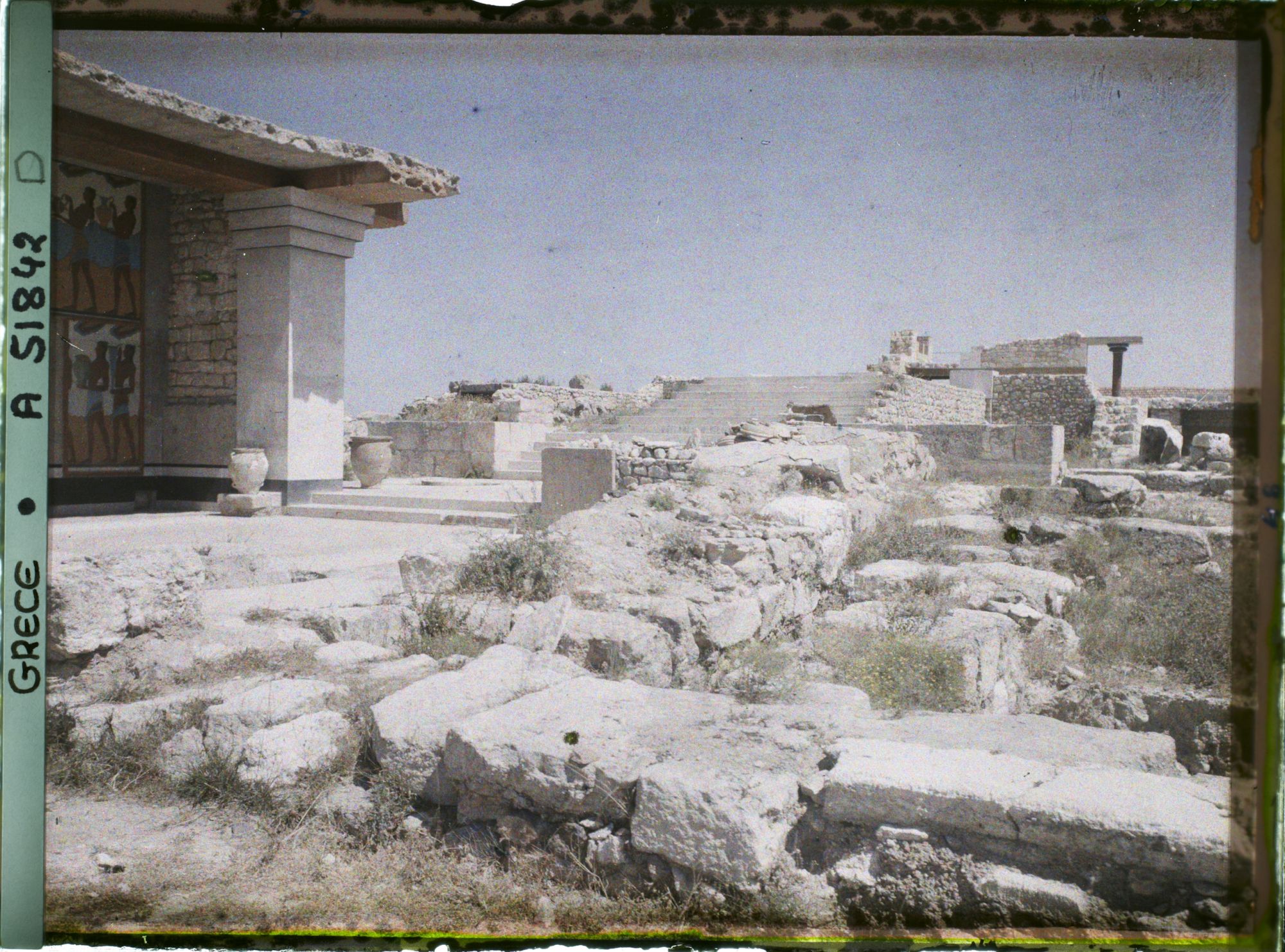 Image représentant Dans le Palais. A gauche, les Propylées sud (entrée du Palais, au bout du couloir de la procession) et au fond, l'escalier d'honneur qui serait aux étages supérieurs de l'aile orientale