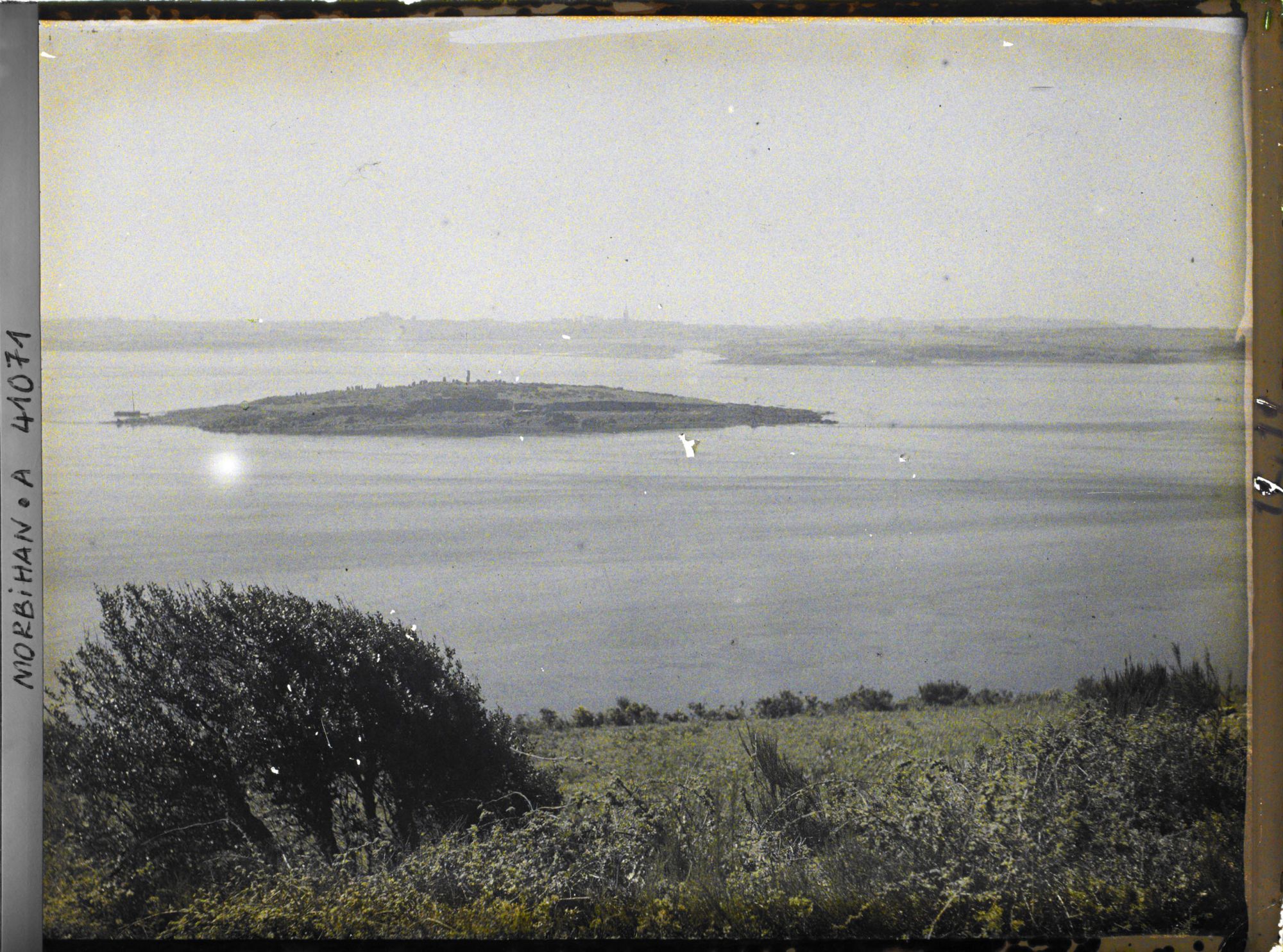 Image représentant L'îlot d'Er Lannic où l'on distingue plusieurs menhirs des cromlechs, vue prise depuis le tumulus de Gavrinis
