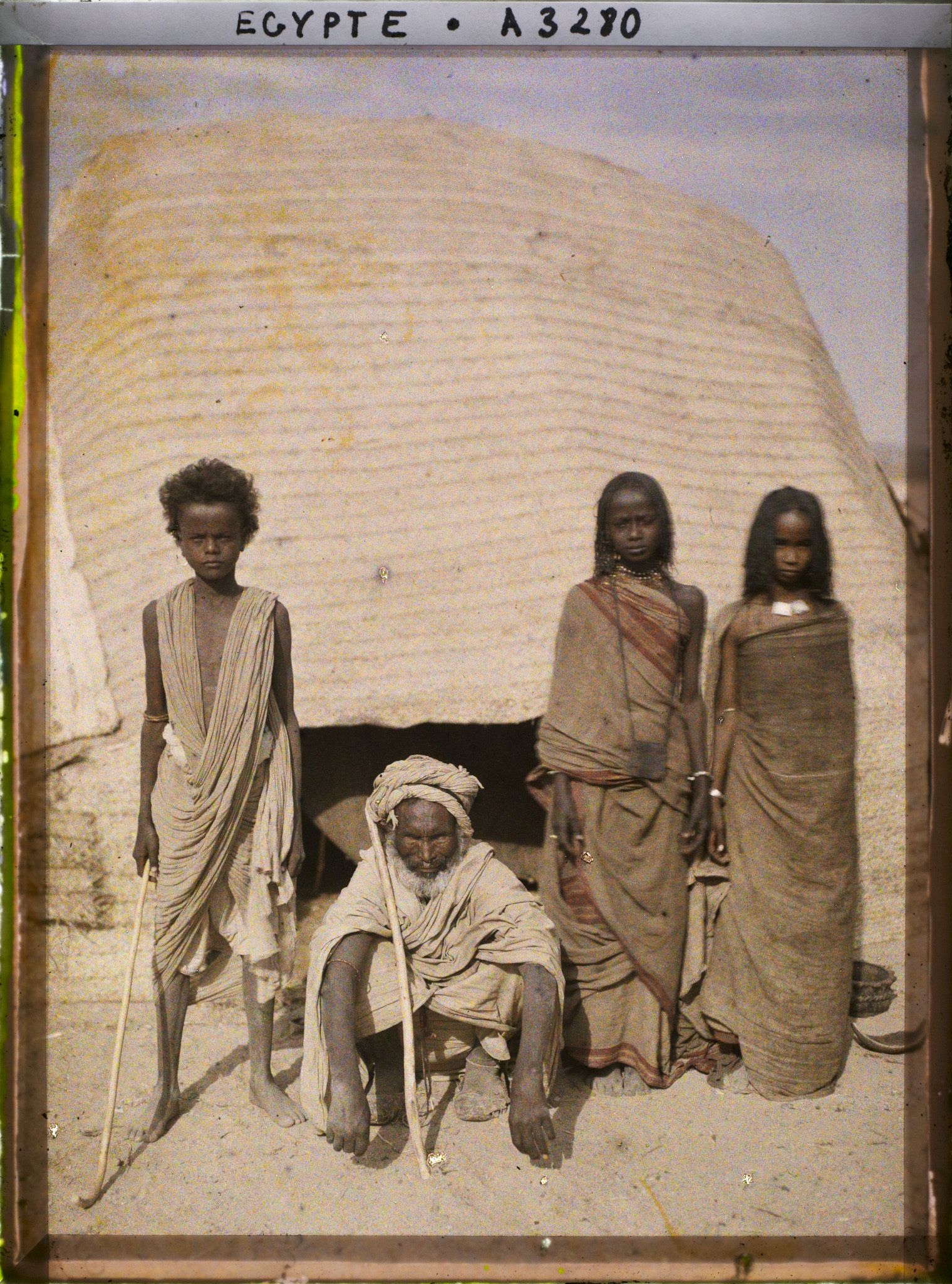 Image représentant Trois enfants et un vieillard  null bishari posent pour l'opérateur devant l'entrée d'une habitation