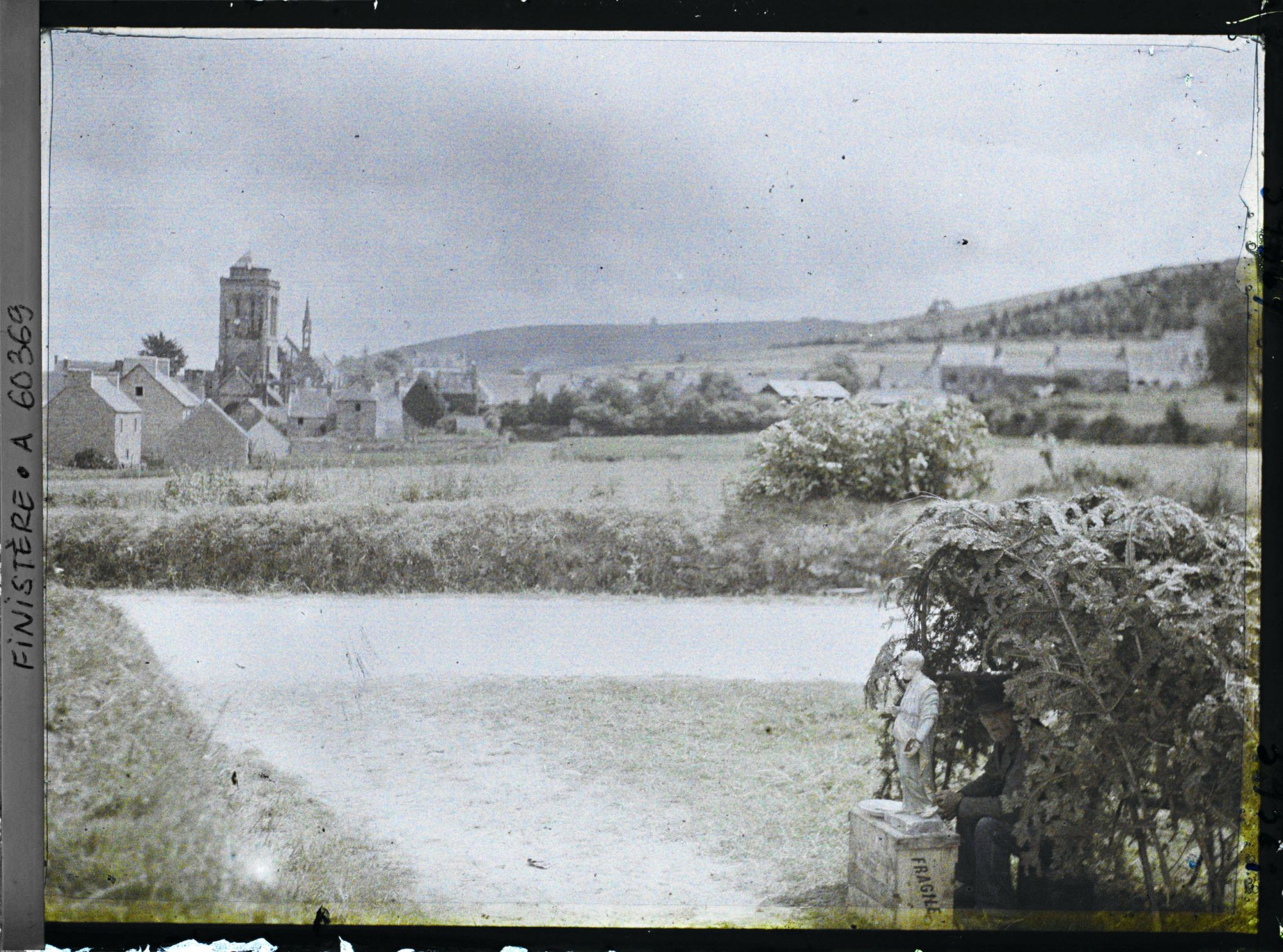 Image représentant Un reposoir sur le parcours de la Grande Troménie avec à l'arrière-plan le bourg de Locronan et la tour de l'église Saint-Ronan