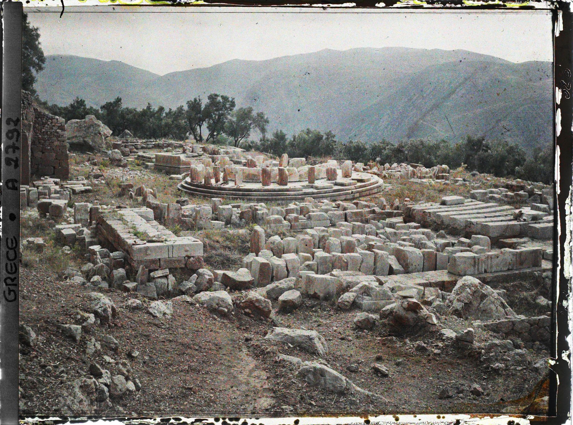 Image représentant Sanctuaire de Marmaria : Au premier plan, le Temple d'Athéna Pronaia. Au second, le Tholos (petit temple du sanctuaire d'Athéna)