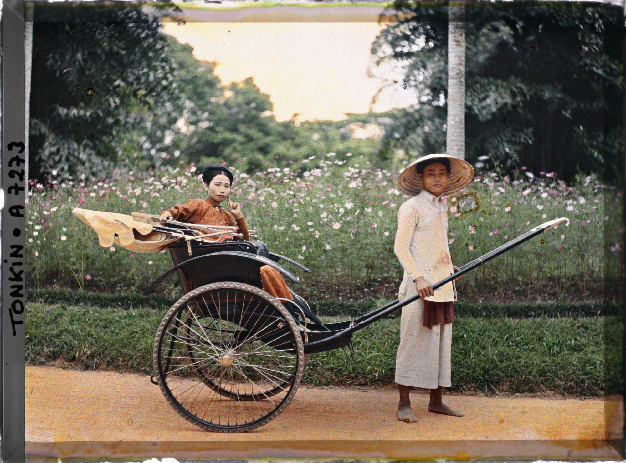 Image représentant Une jeune élégante de la classe aisée, en pousse-pousse dans un jardin public