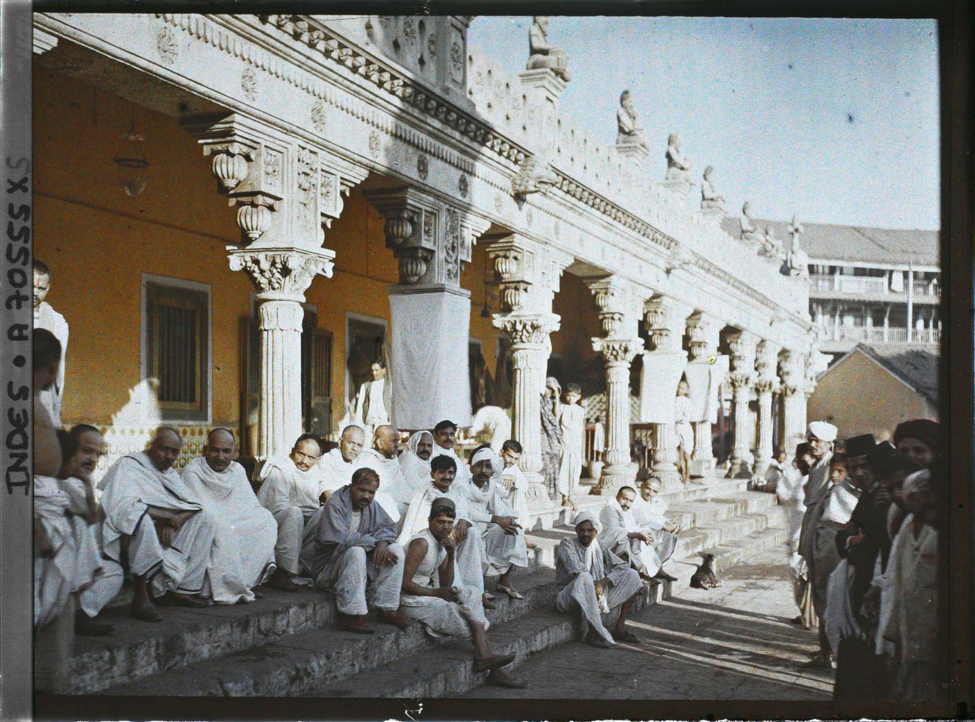 Image représentant Groupe d'hommes vêtus de blanc, assis sur les marches d'un temple hindou