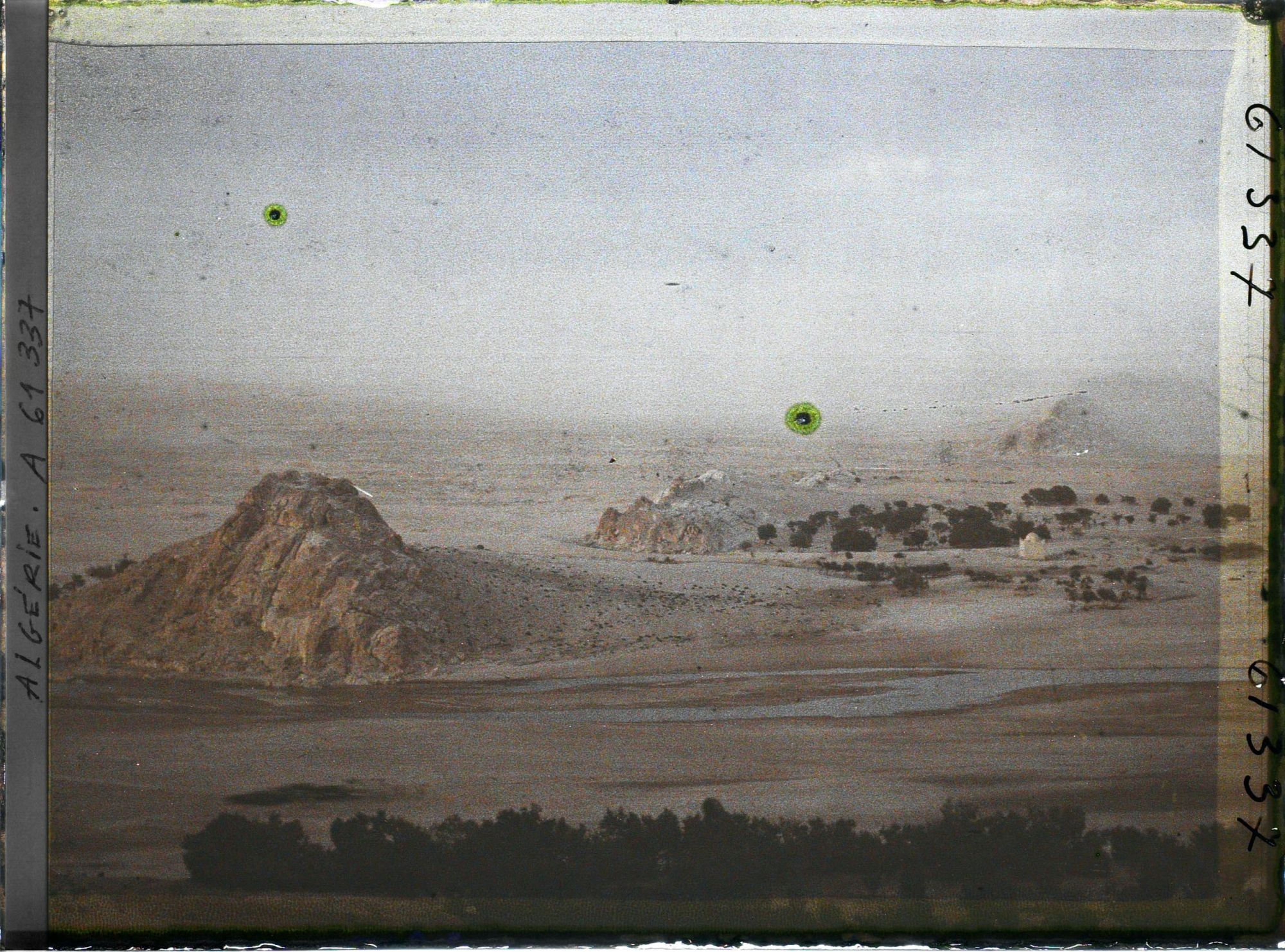 Image représentant Le lit de l'Oued Mzi avec à l'arrière-plan une tempête de sable