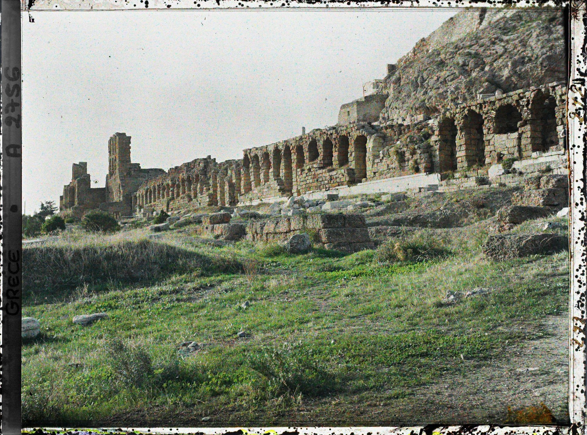 Image représentant A gauche, l'Odéon d'Herode Atticus, prolongé par le portique d'Eumene