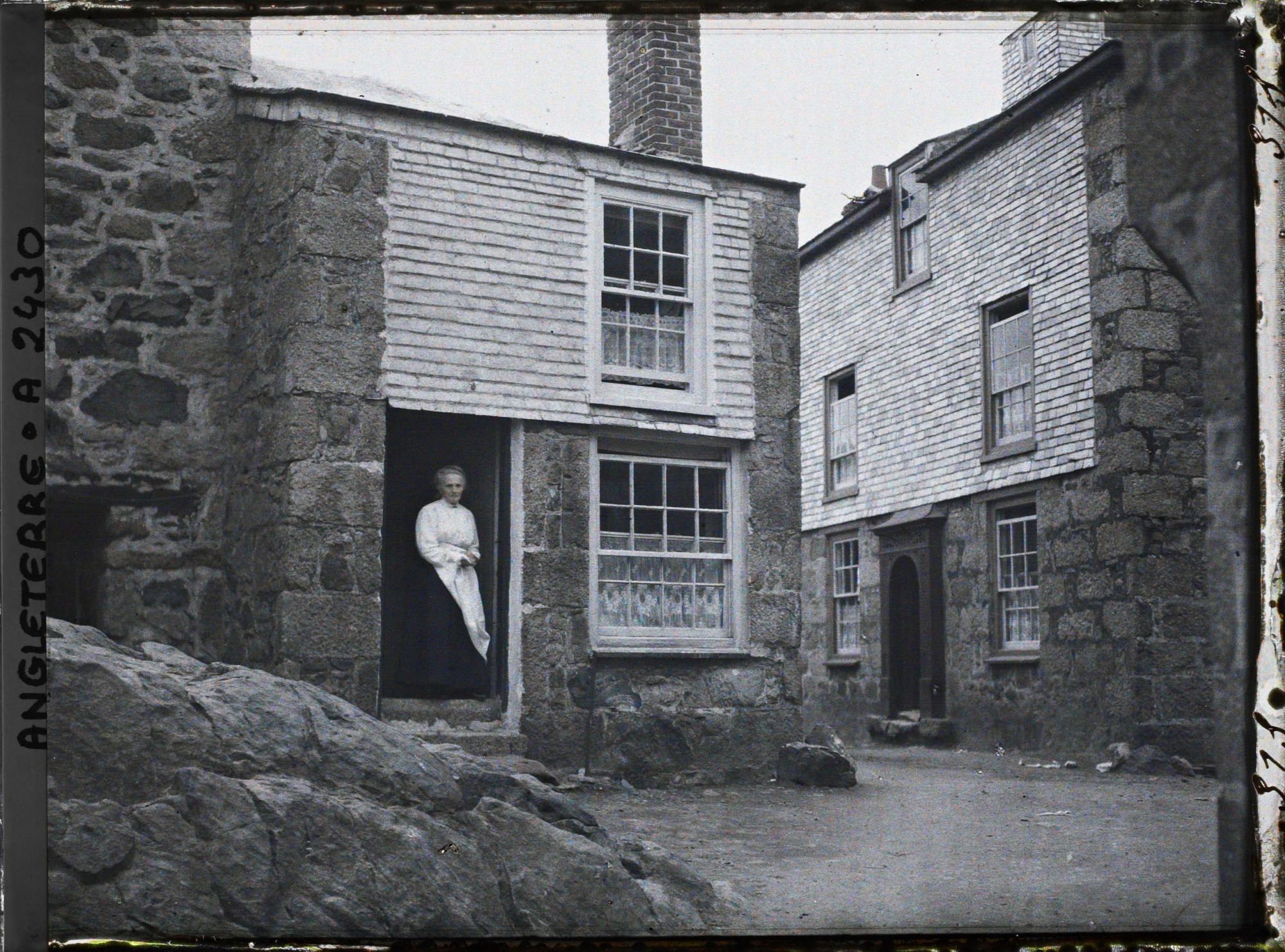 Image représentant Femme se tenant sur le seuil de sa maison