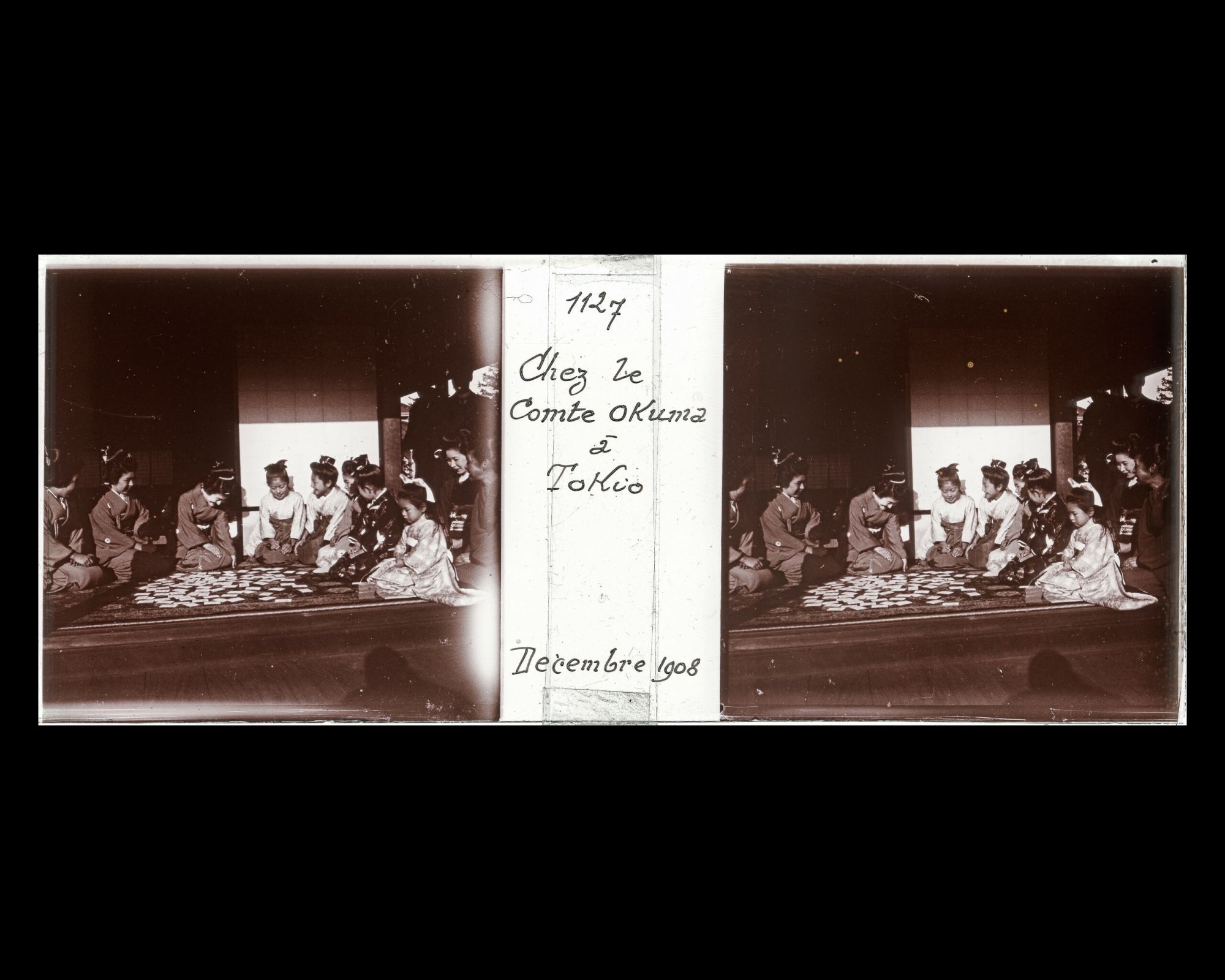 Image représentant Dames et jeunes filles de la famille Okuma jouant à un jeu de cartes traditionnel, lors d'une réception