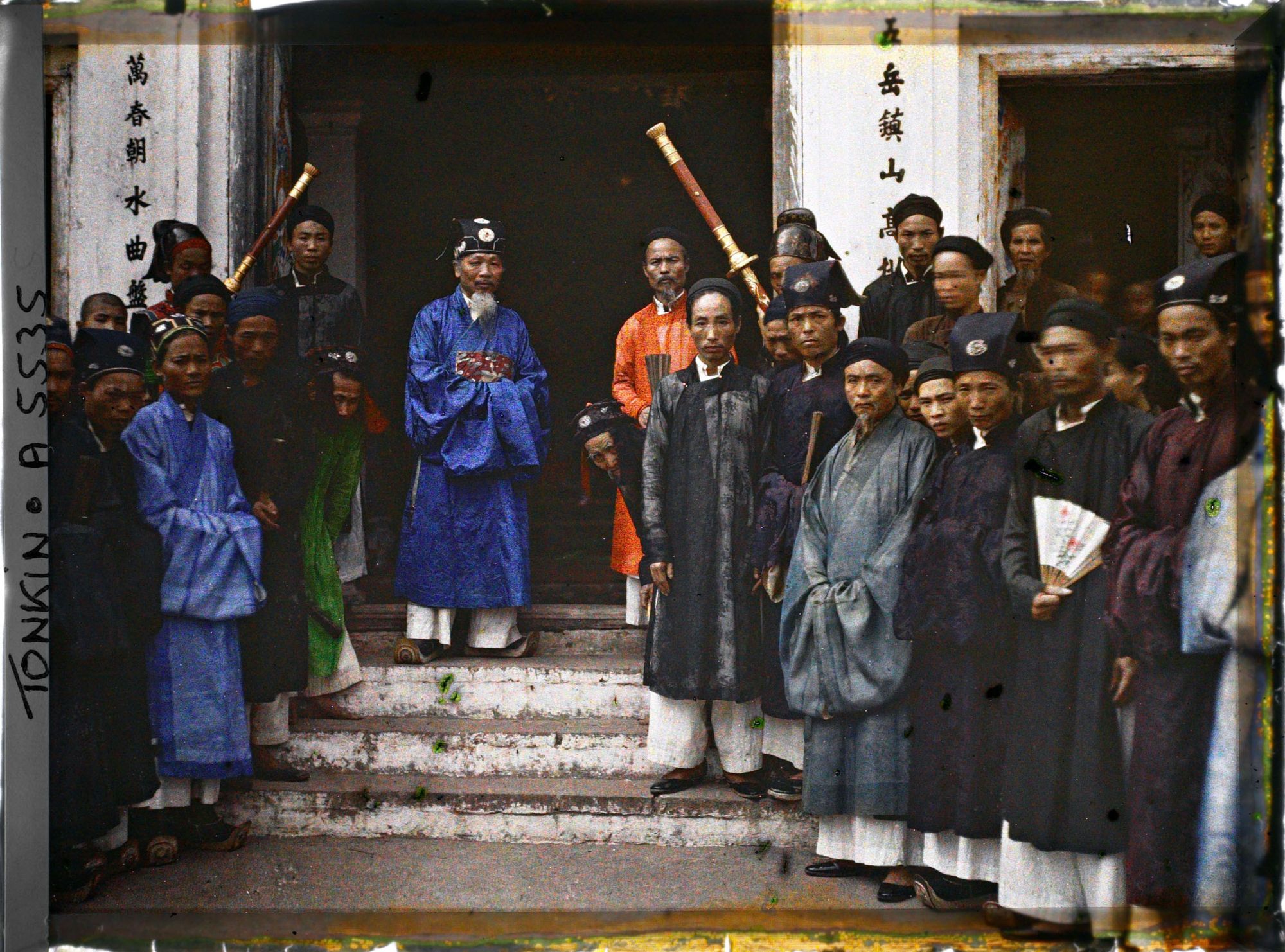 Image représentant Le chef de canton et les autorités villageoises réunis devant le Dinh (maison communale)