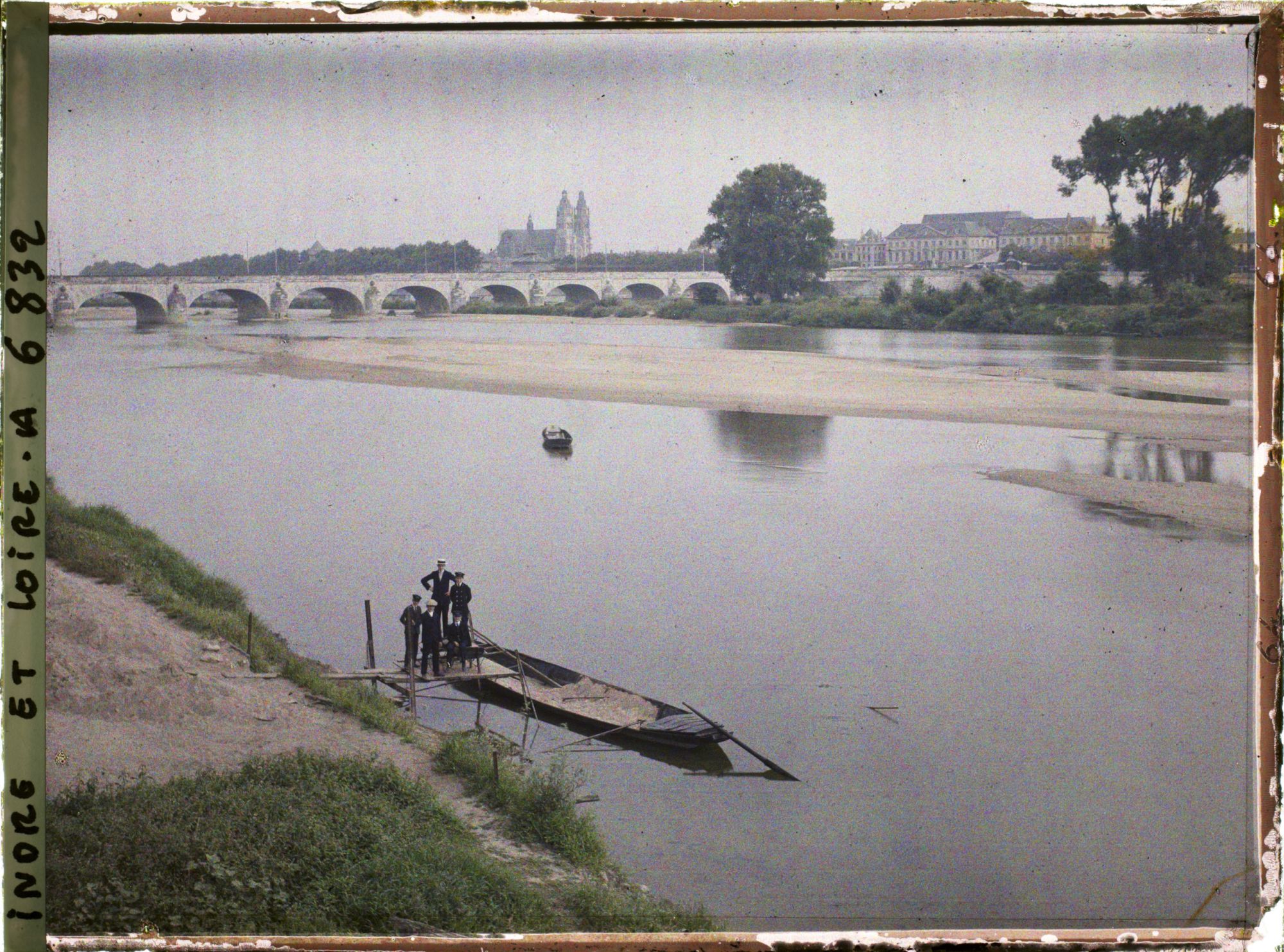 Image représentant Une barque typique de Loire amarrée, au second plan le pont Wilson et la cathédrale