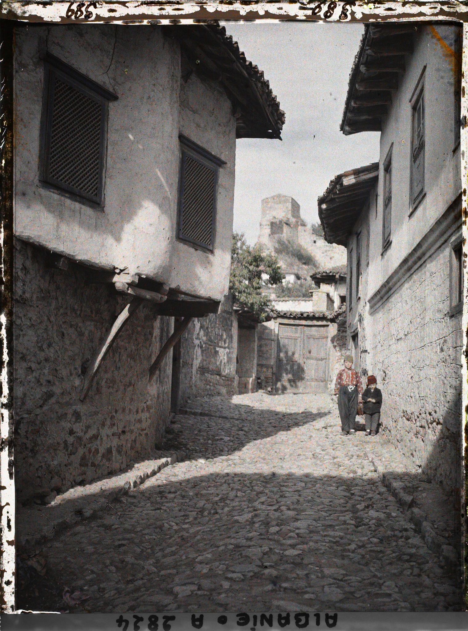 Image représentant Rue à maisons à encorbellements avec au loin les vestiges d'un bastion d'origine vénitienne