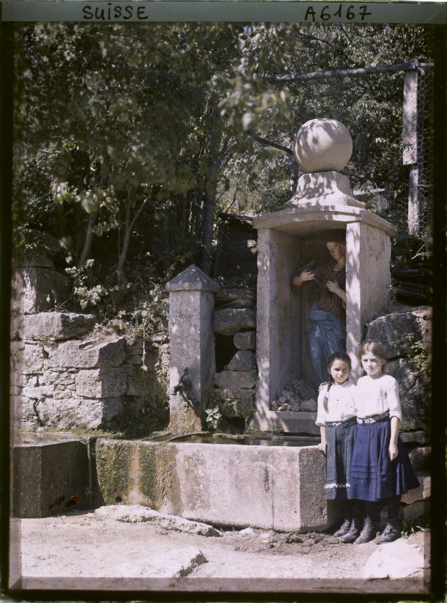 Image représentant Deux filles posent devant une fontaine entre Hofstetten-Flüh et Metzerlen-Mariastein