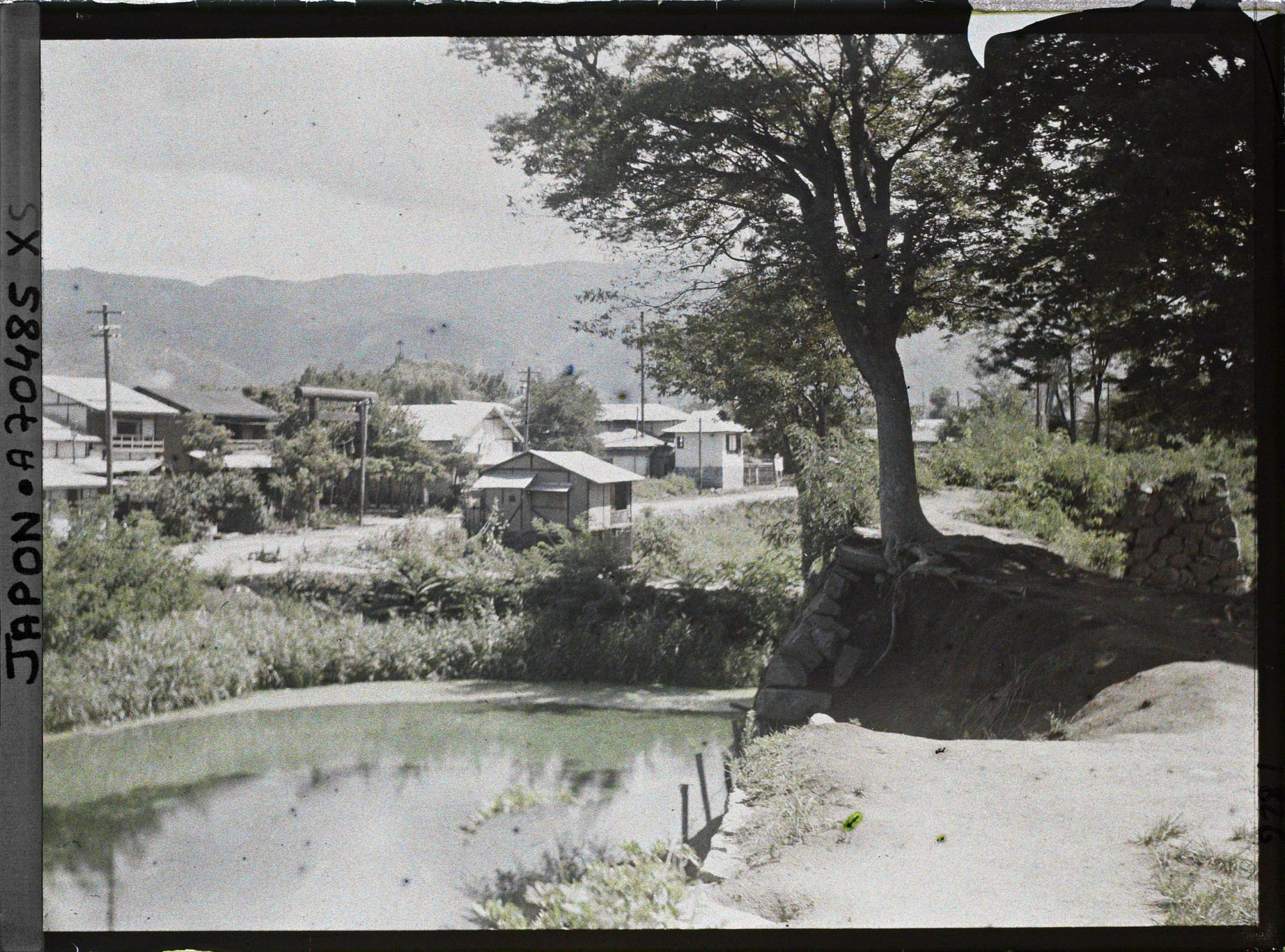 Image représentant Ruines d'anciennes douves ou simple cours d'eau (?) et une partie de la ville